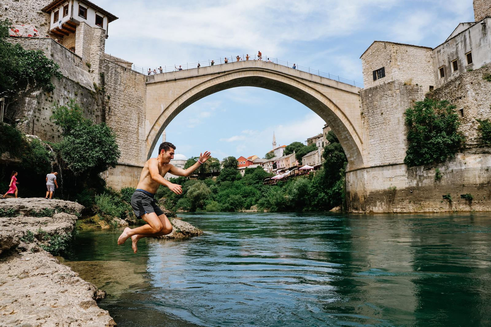 05.06.2022. Mostar - Stari grad pun turista koji vrijedno nagradjuju hrabre skakace za skok sa Starog mosta. Oni hrabriji spas od vrucina traze u hladnoj Neretvi. Photo: Denis Kapetanovic/PIXSELL