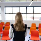 Rear view of a Caucasian woman with long blond hair, wearing smart clothes, standing in an empty modern meeting room, training her speech for conference.,Image: 532618463, License: Rights-managed, Restrictions: , Model Release: yes, Credit line: Wavebreak Media LTD / Wavebreak / Profimedia