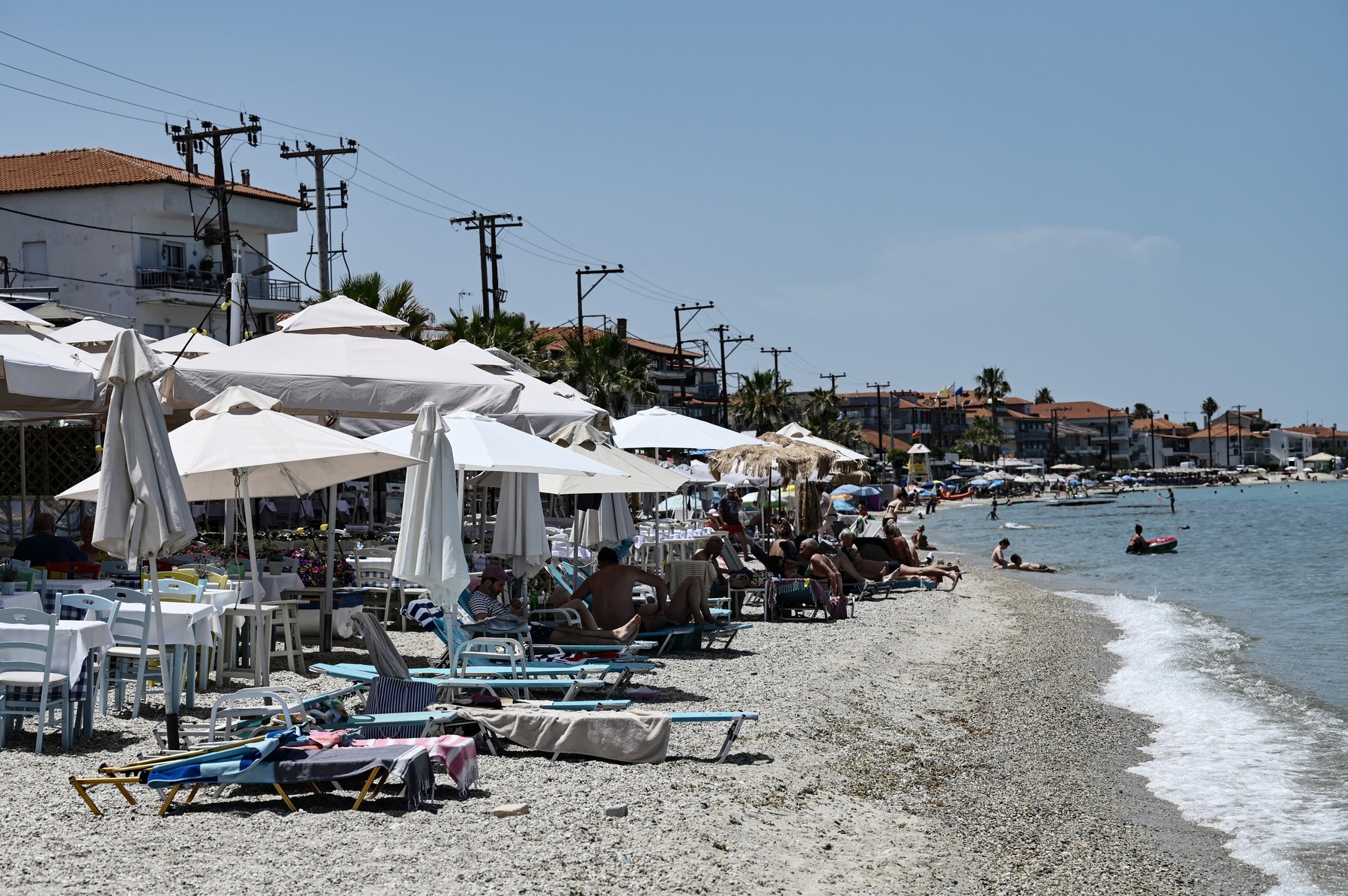 Sunbathers stand in a beach bar in Halkidiki Peninsula, on June 7, 2024. Last year, nearly 33 million people visited Greece, five more than in 2022.
The problem with beaches in Greece is that there are entrepreneurs who, either with a permit or through encroachment, cover parts of the coast with sunbeds, umbrellas, tables and even permanent structures. The "beach towel movement" activists, forced authorities to take a closer look at a widespread practise of illegal beach encroachment by tourism operators.,Image: 883549567, License: Rights-managed, Restrictions: , Model Release: no, Credit line: Sakis MITROLIDIS / AFP / Profimedia