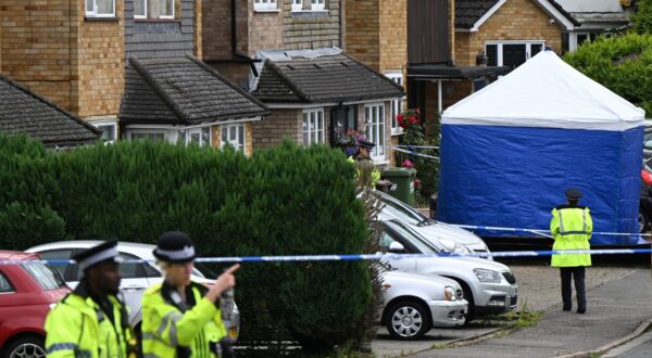 Police officers stand guard by a forensic team tent at Ashley Close in Bushey in the borough of Hertfordshire, north of London, on July 10, 2024 after a triple "crossbow attack" murder. British police were searching for a suspect who may have a crossbow after the wife and two daughters of a BBC radio racing commentator were killed in what police believe was a "targeted" attack.,Image: 888779318, License: Rights-managed, Restrictions: , Model Release: no, Credit line: JUSTIN TALLIS / AFP / Profimedia