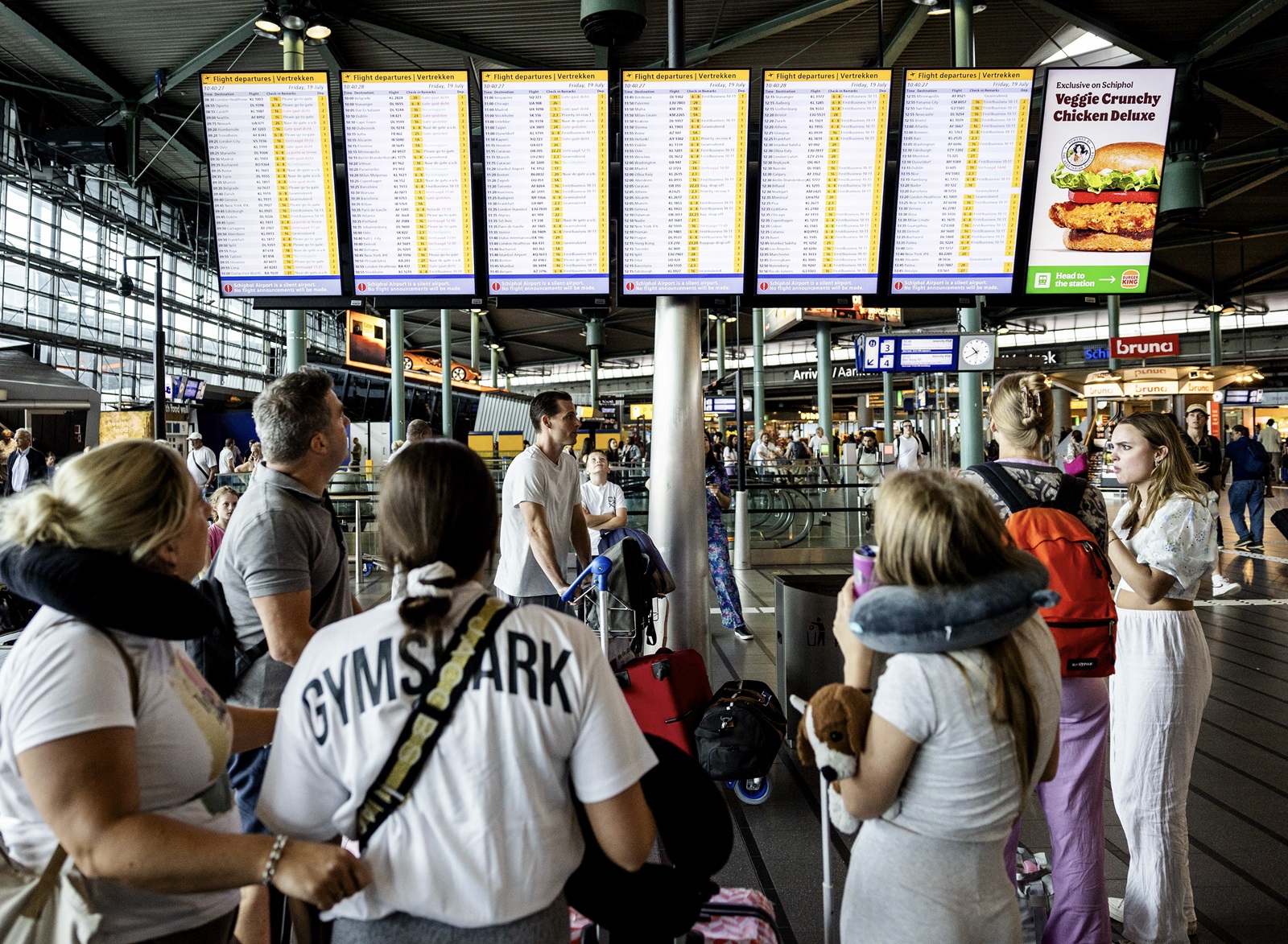 epa11487087 Passengers look at signs displaying departure information at Schiphol Airport, southwest of Amsterdam, in the Netherlands, 19 July 2024. According to the airport's spokesperson, the IT outage has an impact on flights flying from and to Schiphol. Several airports and airlines have reported issues with their IT systems on 19 July, due to a global IT outage.  EPA/SEM VAN DER WAL