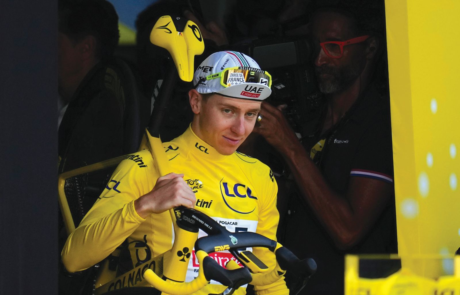 Tour de France winner Slovenia's Tadej Pogacar, wearing the overall leader's yellow jersey, walk to the podium after the twenty-first stage of the Tour de France cycling race, an individual time trial over 33.7 kilometers (20.9 miles) with start in Monaco and finish in Nice, France, Sunday, July 21, 2024. (AP Photo/Daniel Cole)