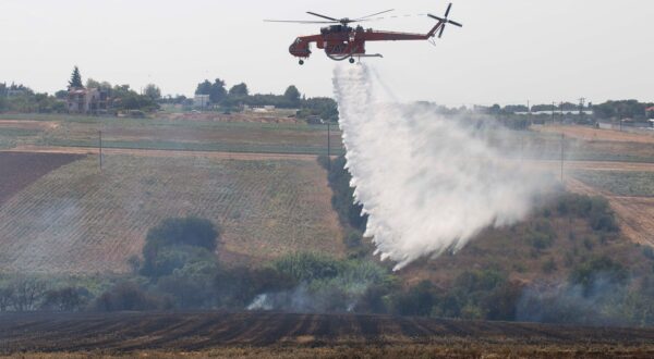 epa11485835 Α firefighting helicopter drops water over a field during a wildfire at Trilofos, near Thessaloniki, Greece, 18 July 2024. A fire that broke out earlier in low vegetation between Trilofos and Plagiario, Thessaloniki, is ongoing. Forty-four firefighters with two groups on foot and 12 fire brigade vehicles are operating to extinguish it. Two of the vehicles and eight firefighters are from Bulgaria, as part of the European Firefighters extension pact. Two firefighting planes and a helicopter are also assisting.  EPA/ACHILLEAS CHIRAS