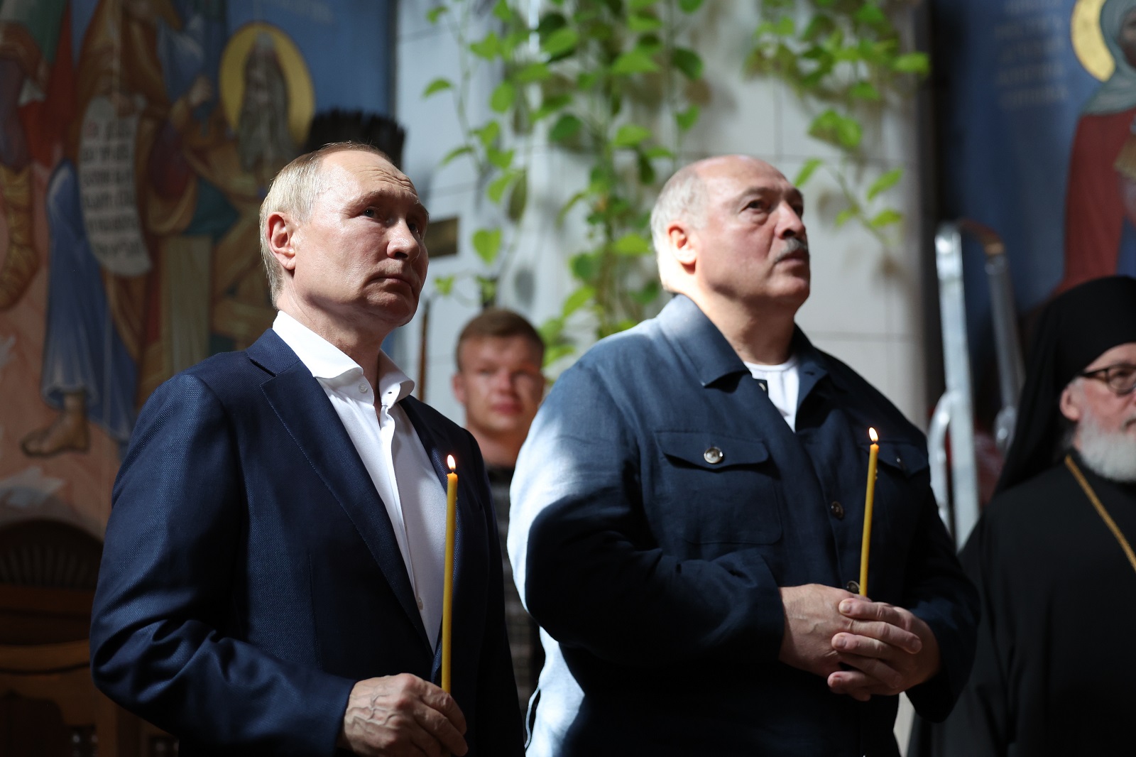 epa11495862 Russian President Vladimir Putin (L) and his Belarusian counterpart Alexander Lukashenko (C) hold candles during their visit to the Valaam Transfiguration Monastery on the Valaam Island in the Ladoga Lake, Republic of Karelia, northwest Russia, 25 July 2024. The Belarusian president is on a working visit to Russia.  EPA/ALEXANDER KAZAKOV / SPUTNIK / KREMLIN POOL