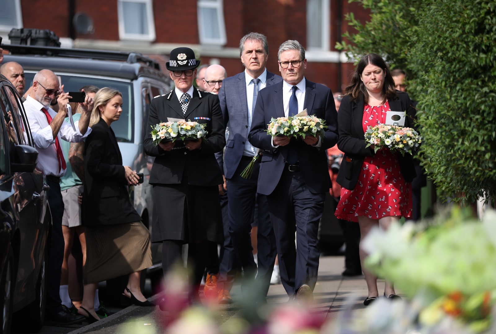 epa11509290 British Prime Minister Keir Starmer (2-R) arrives to lay flowers at the scene of a stabbing attack on Hart Street in Southport, Britain, 30 July 2024. Merseyside Police have confirmed that a third child, aged 9, has died as a result of a knife attack in Southport and confirmed that the other two victims were ages six and seven. Eight other children remain in critical condition along with two adults. Armed police arrested a 17-year-old boy on suspicion of murder and attempted murder, and while the motivation for the attack remains unclear, it is not being treated as terrorist-related.  EPA/ADAM VAUGHAN