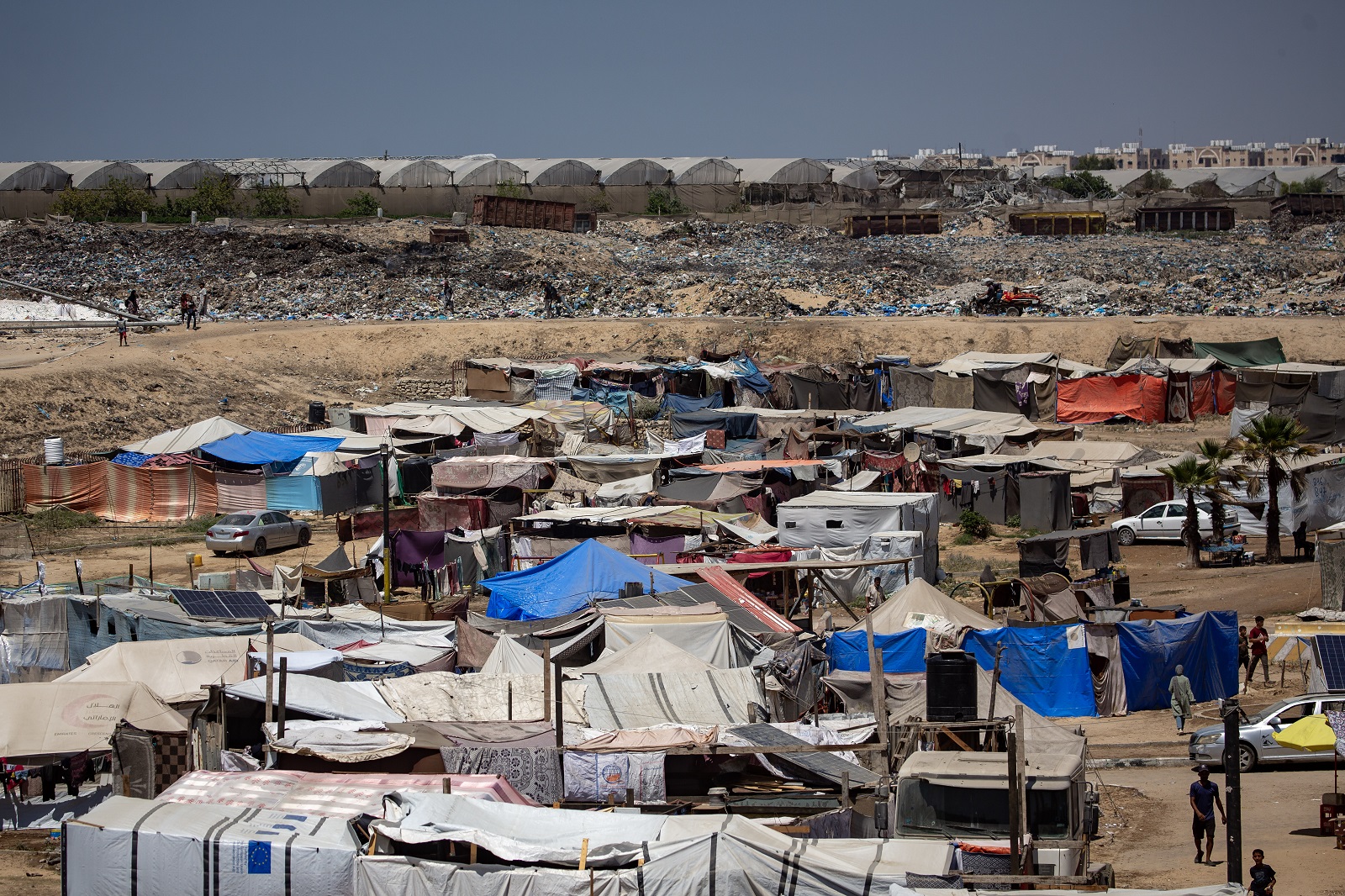 epa11515459 Displaced Palestinians set up their tents next to sewage and a garbage dump on a street in Khan Younis camp in the southern Gaza Strip, 01 August 2024. Since 07 October 2023, up to 1.7 million people, or more than 75 percent of the population, have been displaced throughout the Gaza Strip, some more than once, in search of safety, according to the United Nations Relief and Works Agency for Palestine Refugees in the Near East (UNRWA), which added that the Palestinian enclave is 'on the brink of famine', with 1.1 million people (half of its population) 'experiencing catastrophic food insecurity' due to the conflict and restrictions on humanitarian access.  EPA/HAITHAM IMAD