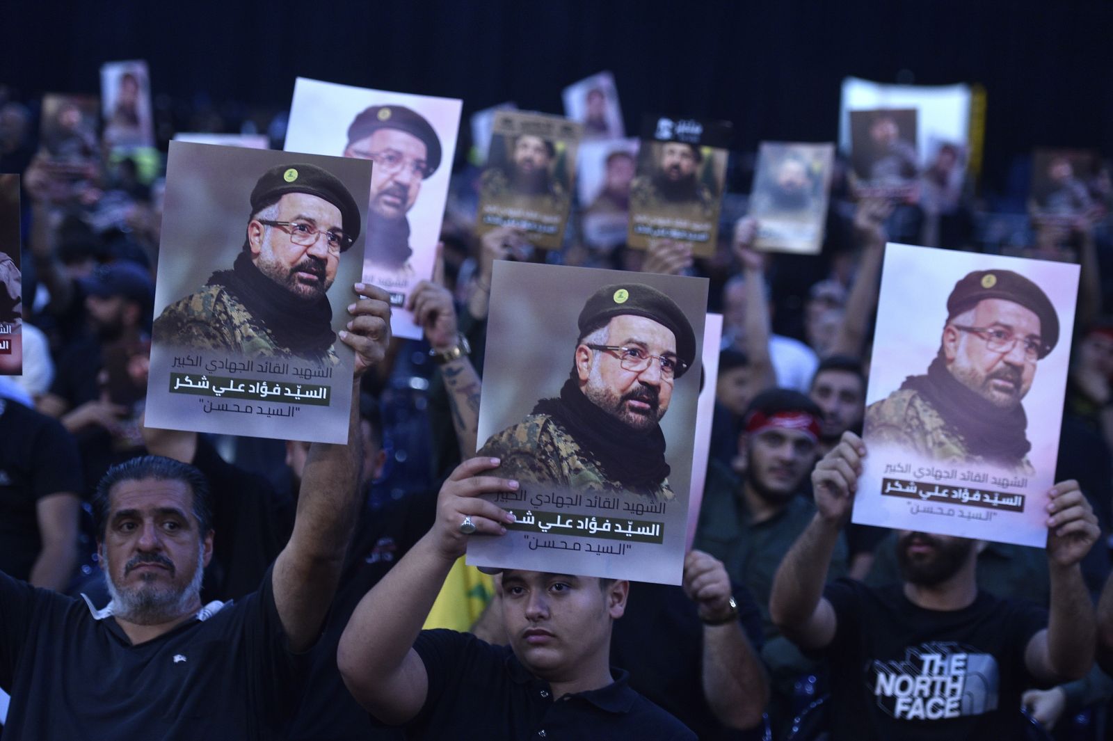 epa11515825 Mourners hold pictures as they attend the funeral procession for late senior Hezbollah commander Fuad Shukr, killed in an Israeli strike, in Beirut, Lebanon, 01 August 2024. Hezbollah and the Israel Defense Forces (IDF) confirmed that Shukr was killed in an Israeli strike on 30 July in the Haret Hreik neighborhood of Beirut. Lebanon's state media said at least four people were killed.  EPA/WAEL HAMZEH