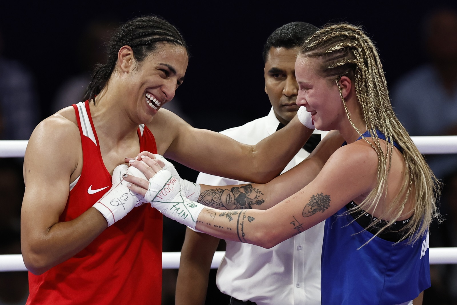 epa11522795 Imane Khelif of Algeria (red) and Anna Luca Hamori of Hungary (blue) hug in their Women 66kg Quarterfinal bout of the Boxing competitions in the Paris 2024 Olympic Games, at the North Paris Arena in Villepinte, France, 03 August 2024.  EPA/Miguel Tona