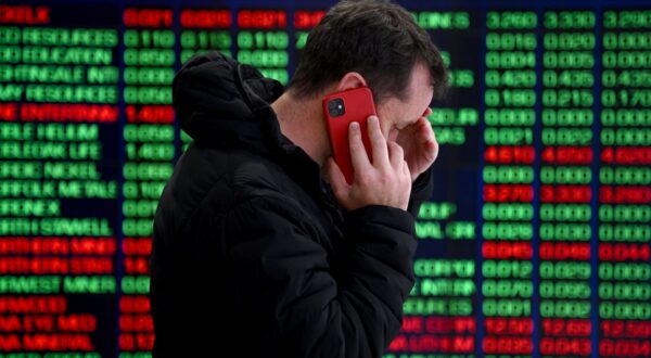 epaselect epa11526596 A person talks on the phone in front of indicator boards at the Australian Securities Exchange (ASX) in Sydney, Australia, 05 August 2024. The ASX has plummeted over fears of US recession, trading at its lowest single day since 2022.  EPA/BIANCA DE MARCHI AUSTRALIA AND NEW ZEALAND OUT