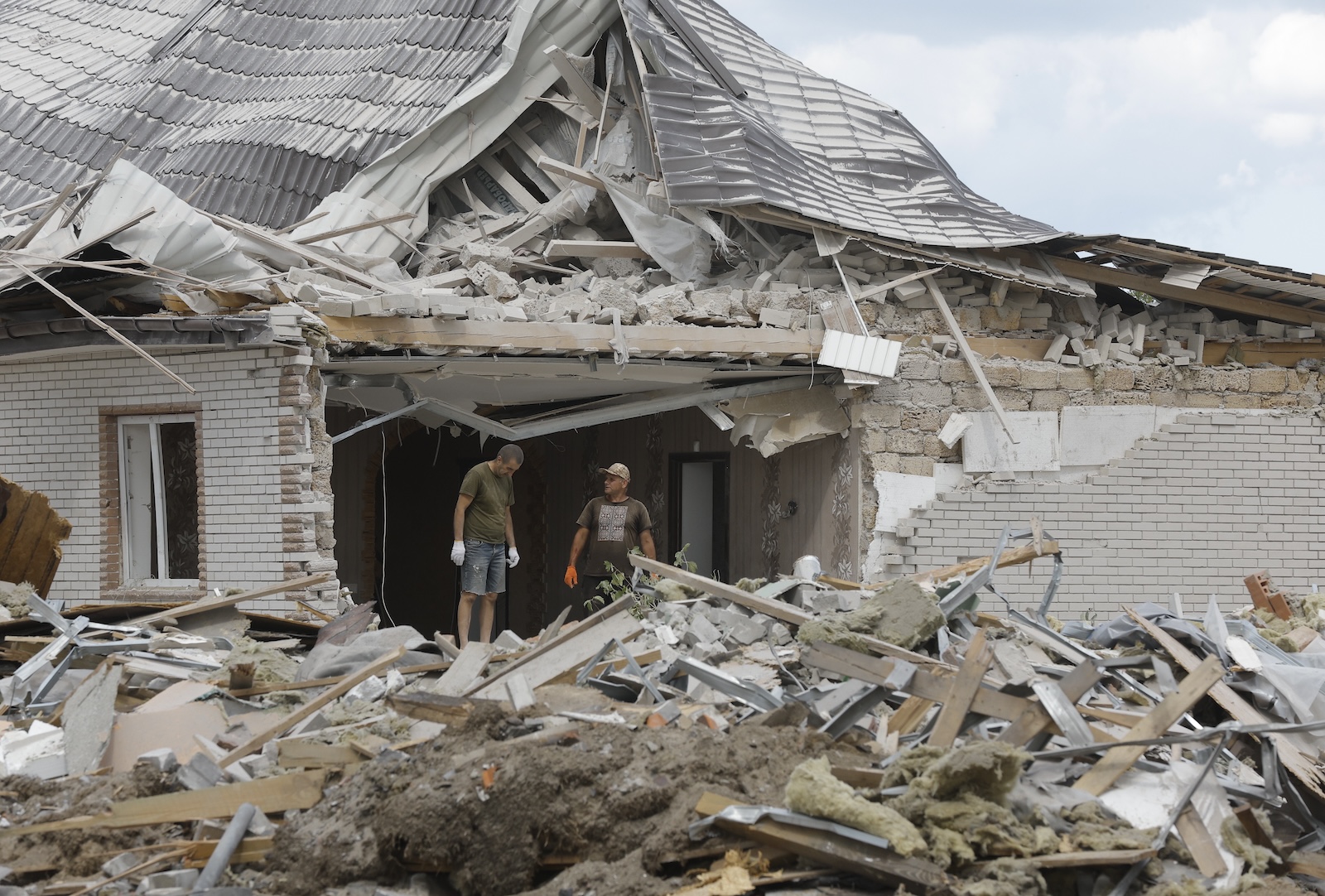 epa11545322 Locals clear debris following a rocket strike on a private building in a village near Brovary, Kyiv region, Ukraine, 11 August 2024, amid the Russian invasion. A man and his four-year-old son were killed while three other people were injured in an overnight Russian missile strike, the State Emergency Service of Ukraine said on 11 August.  EPA/SERGEY DOLZHENKO 59898