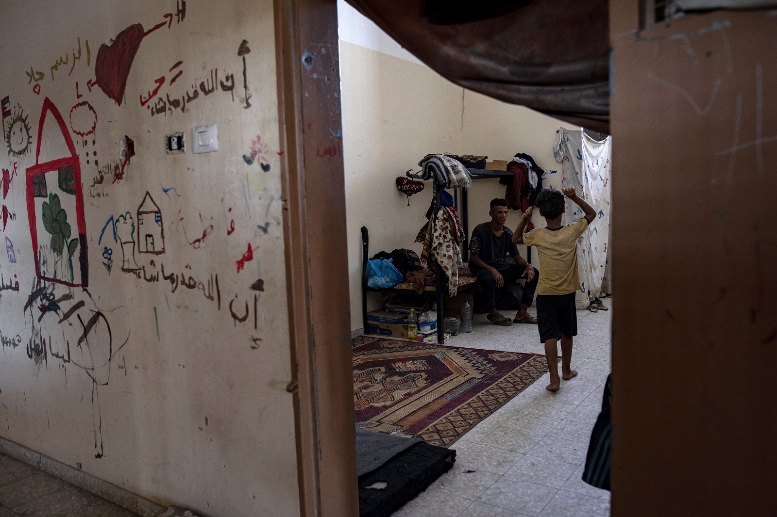 epa11549011 Palestinians inside the Asdaa Central Prison facility, which has been converted into a shelter for internally displaced people, in Khan Younis, southern Gaza Strip, 14 August 2024. Since 07 October 2023, up to 1.7 million people, or more than 75 percent of the population, have been displaced throughout the Gaza Strip, some more than once, in search of safety, according to the United Nations Relief and Works Agency for Palestine Refugees in the Near East (UNRWA), which added that the Palestinian enclave is 'on the brink of famine', with 1.1 million people (half of its population) 'experiencing catastrophic food insecurity' due to the conflict and restrictions on humanitarian access.  EPA/HAITHAM IMAD