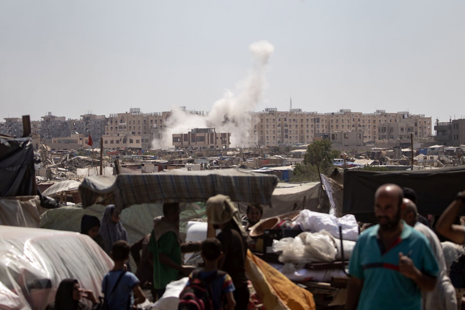 epaselect epa11553964 People (front) flee as smoke rises amid the advance of Israeli military vehicles in an area sheltering internally displaced Palestinians, in Khan Yunis, southern Gaza Strip, 18 August 2024. Israel said on 18 August that the IDF was continuing operational activities in the areas of Khan Younis and Deir al-Balah, southern Gaza. More than 40,000 Palestinians and over 1,400 Israelis have been killed, according to the Palestinian Health Ministry and the Israel Defense Forces (IDF), since Hamas militants launched an attack against Israel from the Gaza Strip on 07 October 2023, and the Israeli operations in Gaza and the West Bank which followed it.  EPA/HAITHAM IMAD