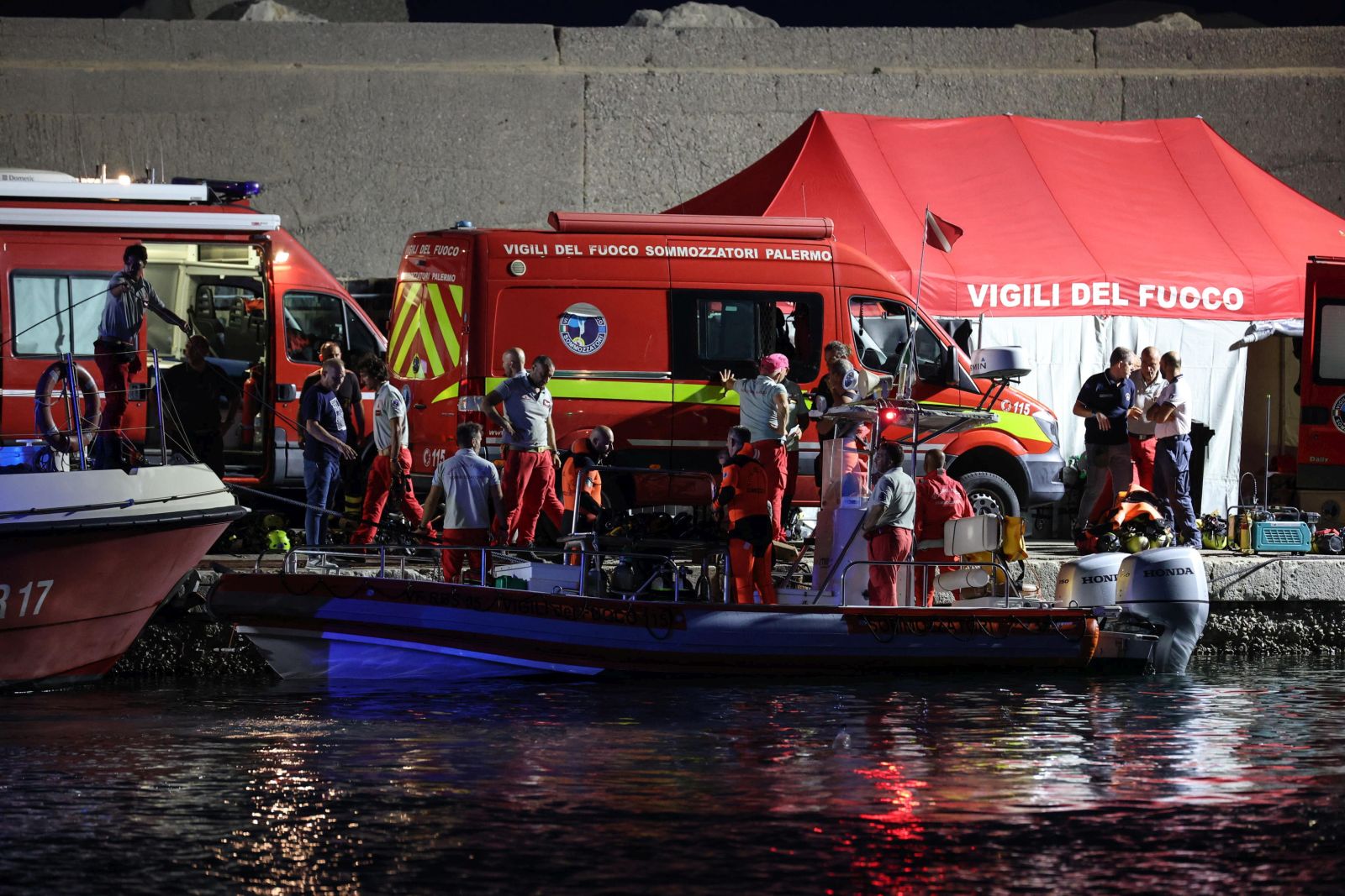 epa11556992 Rescue workers and divers from the Italian fire brigade work as a rescue operation continues for the missing people who were on board a sailboat that sank, in Porticello, Sicily Island, Italy, 20 August 2024. At least one person died, six remain missing and 15 passengers were rescued, after a 56-meter-long luxury sailboat, the Bayesian, with 22 people on board, sank on 19 August off Porticello, near Palermo, after a tornado hit the area. The six missing people have not yet been identified as dive teams are trying to find access into the yacht's cabins, sitting at 50 m below the surface of the water.  EPA/IGOR PETYX