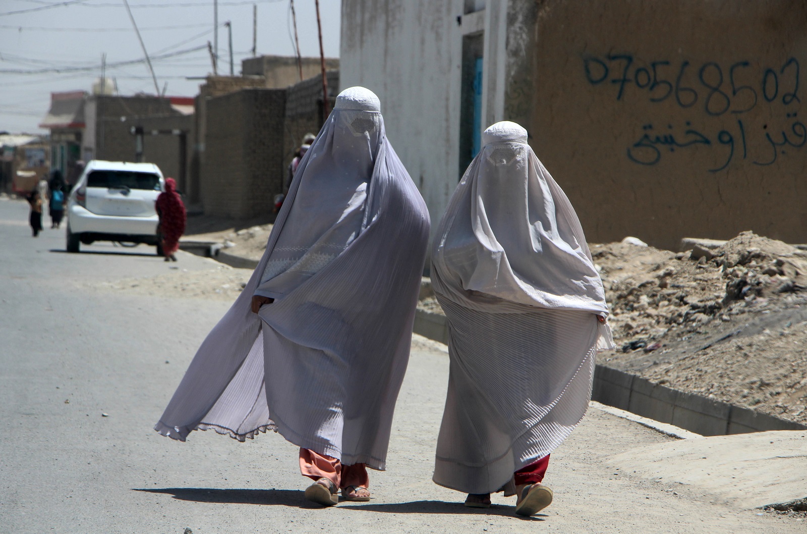 epa11560358 Burqa-clad Afghan women walk on a road in Kandahar, Afghanistan, 22 August 2024. The Taliban in Afghanistan have enforced new laws mandating that women must cover their bodies and faces in public, citing these measures as necessary to promote virtue and prevent vice, the Ministry for the Propagation of Virtue and Prevention of Vice said. Approved by their Supreme Leader Hibatullah Akhundzada, the regulations include restrictions on women's voices in public, the prohibition of images of living beings, and bans on music and mixed-gender interactions. The measures have drawn criticism from the United Nations (UN) for fostering fear and intimidation, especially among women and girls, as the Taliban's Ministry for the Propagation of Virtue and Prevention of Vice expands its control over public life.  EPA/QUDRATULLAH RAZWAN