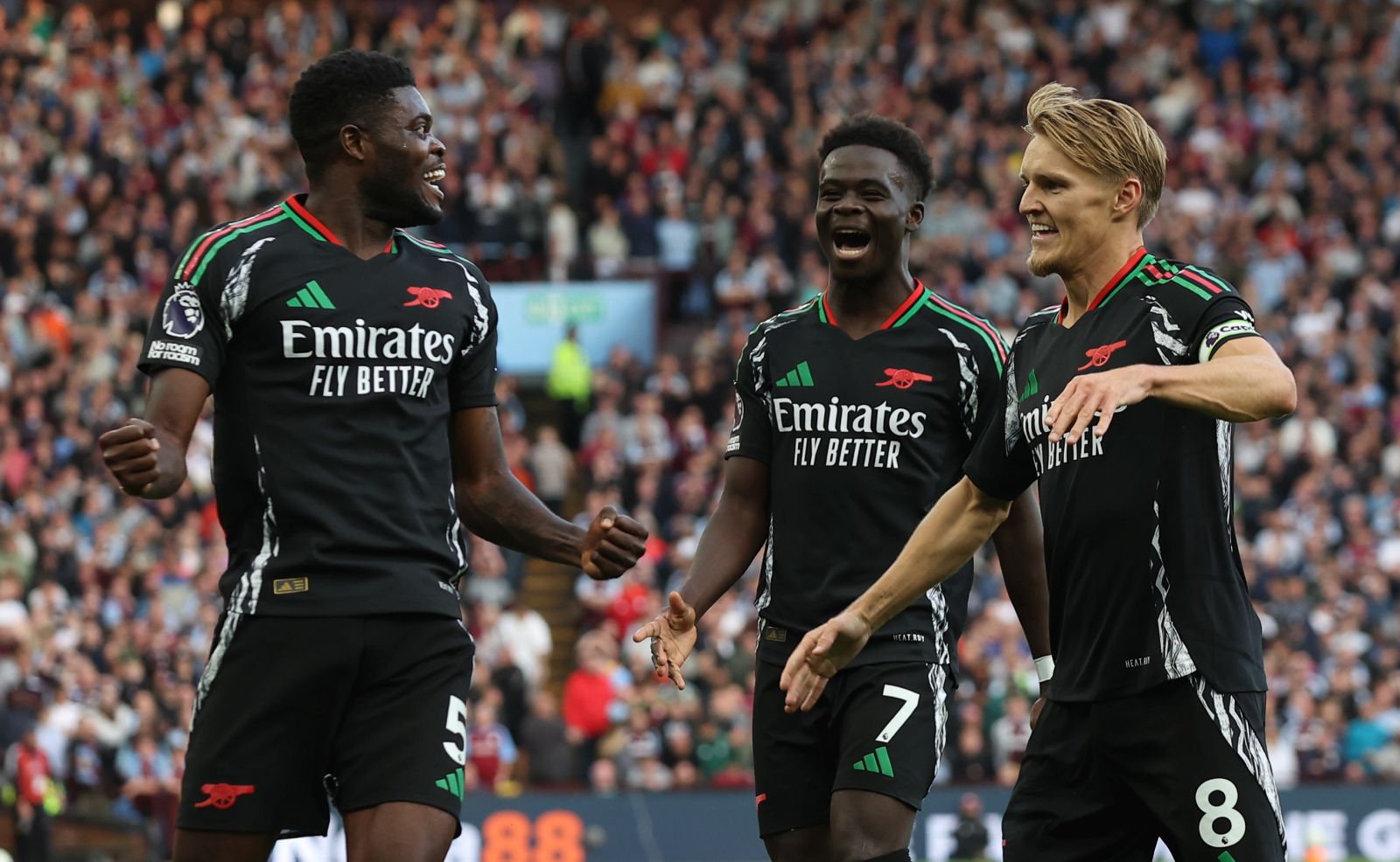 epa11563367 Thomas Partey of Arsenal (L) celebrates scoring the 0-2 goal with Bukayo Saka (C) and Martin Odegaard (R) during the English Premier League soccer match between Aston Villa and Arsenal FC in Birmingham, Britain, 24 August 2024.  EPA/ADAM VAUGHAN EDITORIAL USE ONLY. No use with unauthorized audio, video, data, fixture lists, club/league logos, 'live' services or NFTs. Online in-match use limited to 120 images, no video emulation. No use in betting, games or single club/league/player publications.