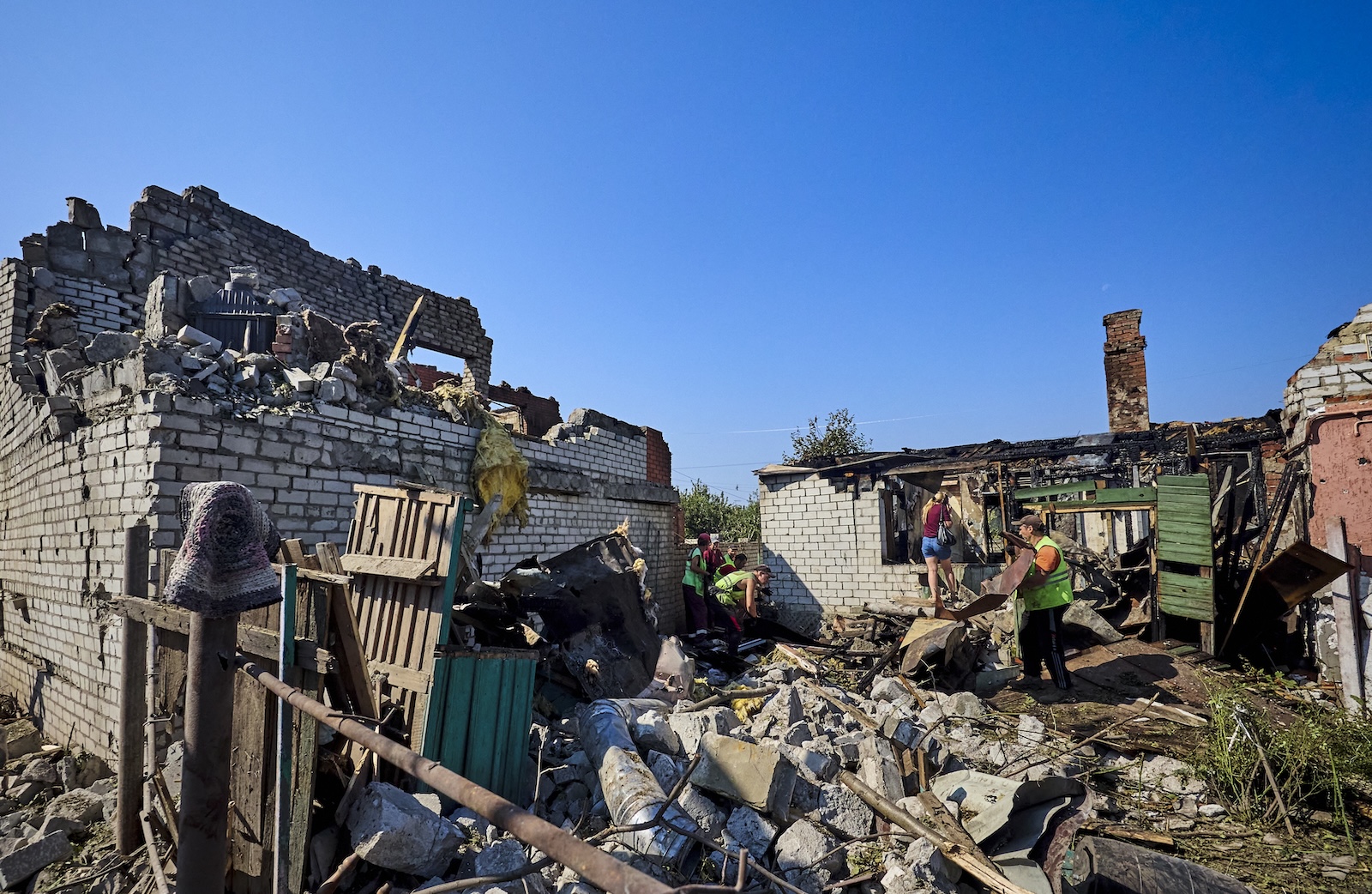 epa11563982 Locals and communal workers clear debris at the scene of a Russian rocket strike in Kharkiv, northeastern Ukraine, 25 August 2024. At least eight people were injured after a morning Russian rocket strike on Kharkiv according to the Mayor Igor Terekhov. Russian troops entered Ukrainian territory on 24 February 2022, starting a conflict that has provoked destruction and a humanitarian crisis.  EPA/SERGEY KOZLOV