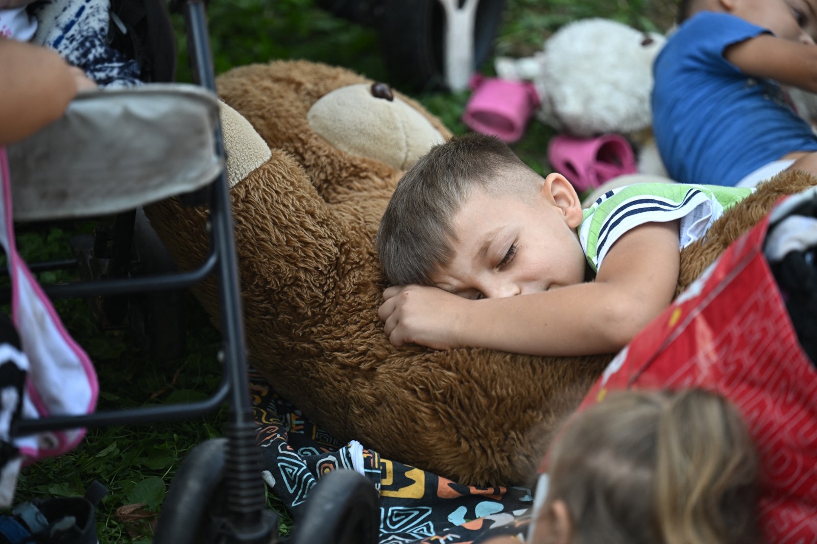 A young boy sleeps on his teddy bear among Ukrainian refugees from Transcarpathia in the village of Kocs, about 70 km north-west from the Hungarian capital Budapest, on August 21, 2024, after some 120 refugees were ousted from their guest house.
 Thousands of Ukrainian refugees face eviction from shelters in Hungary after a legislative change that came into effect on August 21, 2024 took away their access to state-subsidised accommodation. Most were Roma women and children from Transcarpathia in western Ukraine, where there is a large Hungarian community.,Image: 900399170, License: Rights-managed, Restrictions: , Model Release: no, Credit line: Attila KISBENEDEK / AFP / Profimedia