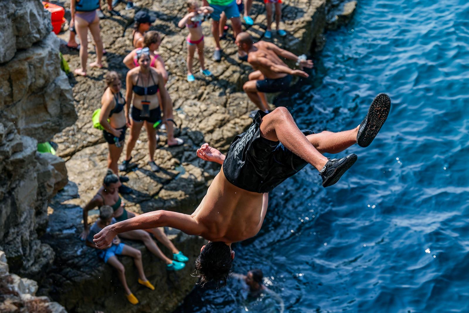 14.08.2024., Pula - Golubove stijene zadnjih su godina postale vrlo popularno mjesto za kajakase te skakace. Naime ovdje je pecina koju rado posjecuju turisti s kajacima, a oni zeljni malo vise adrenalina skacu sa stijena koje se nalaze na samom ulazu u spilju. Photo: Srecko Niketic/PIXSELL