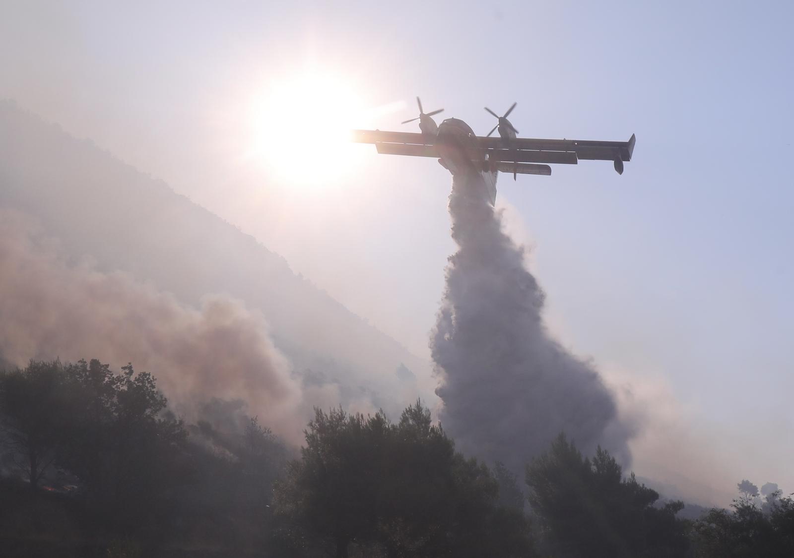 27.08.2024., Zrnovnica - Gasiteljima koji su na pozaristu probdjeli cijelu noc od ranog jutra pomazu kanaderi. Photo: Ivo Cagalj/PIXSELL