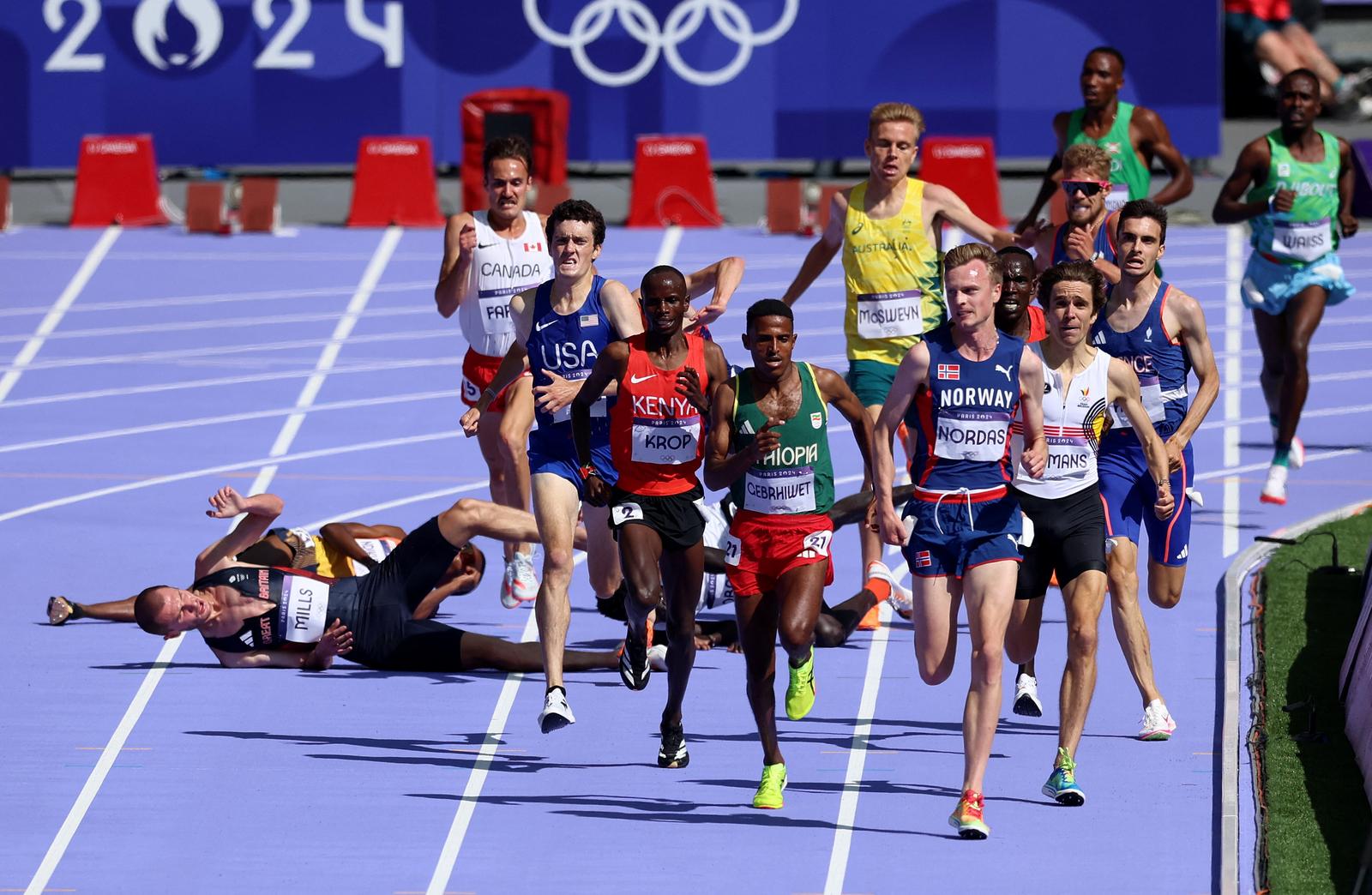 Paris 2024 Olympics - Athletics - Men's 5000m Round 1 - Stade de France, Saint-Denis, France - August 07, 2024. Narve Gilje Nordas of Norway and Hagos Gebrhiwet of Ethiopia in action before finishing first and second place in heat 1 as George Mills of Britain falls. REUTERS/Phil Noble Photo: Phil Noble/REUTERS