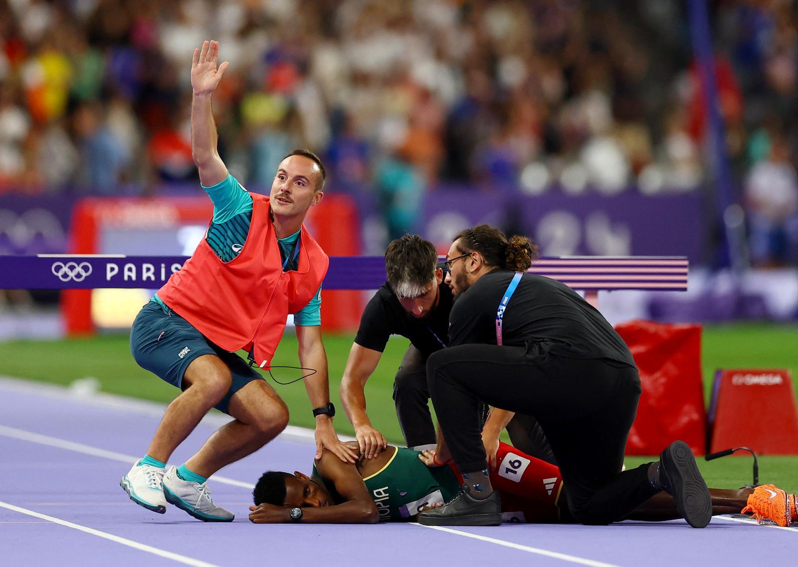 Paris 2024 Olympics - Athletics - Men's 3000m Steeplechase Final - Stade de France, Saint-Denis, France - August 07, 2024. Lamecha Girma of Ethiopia is tended to by medical staff during the Steeplechase final. REUTERS/Stephanie Lecocq Photo: STEPHANIE LECOCQ/REUTERS