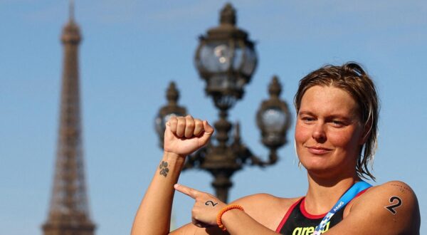 Paris 2024 Olympics - Marathon Swimming - Women's 10km - Paris, France - August 08, 2024. Gold medallist Sharon van Rouwendaal of Netherlands celebrates after the race as the Eiffel Tower is seen. REUTERS/Piroschka Van De Wouw     TPX IMAGES OF THE DAY Photo: Piroschka van de Wouw/REUTERS