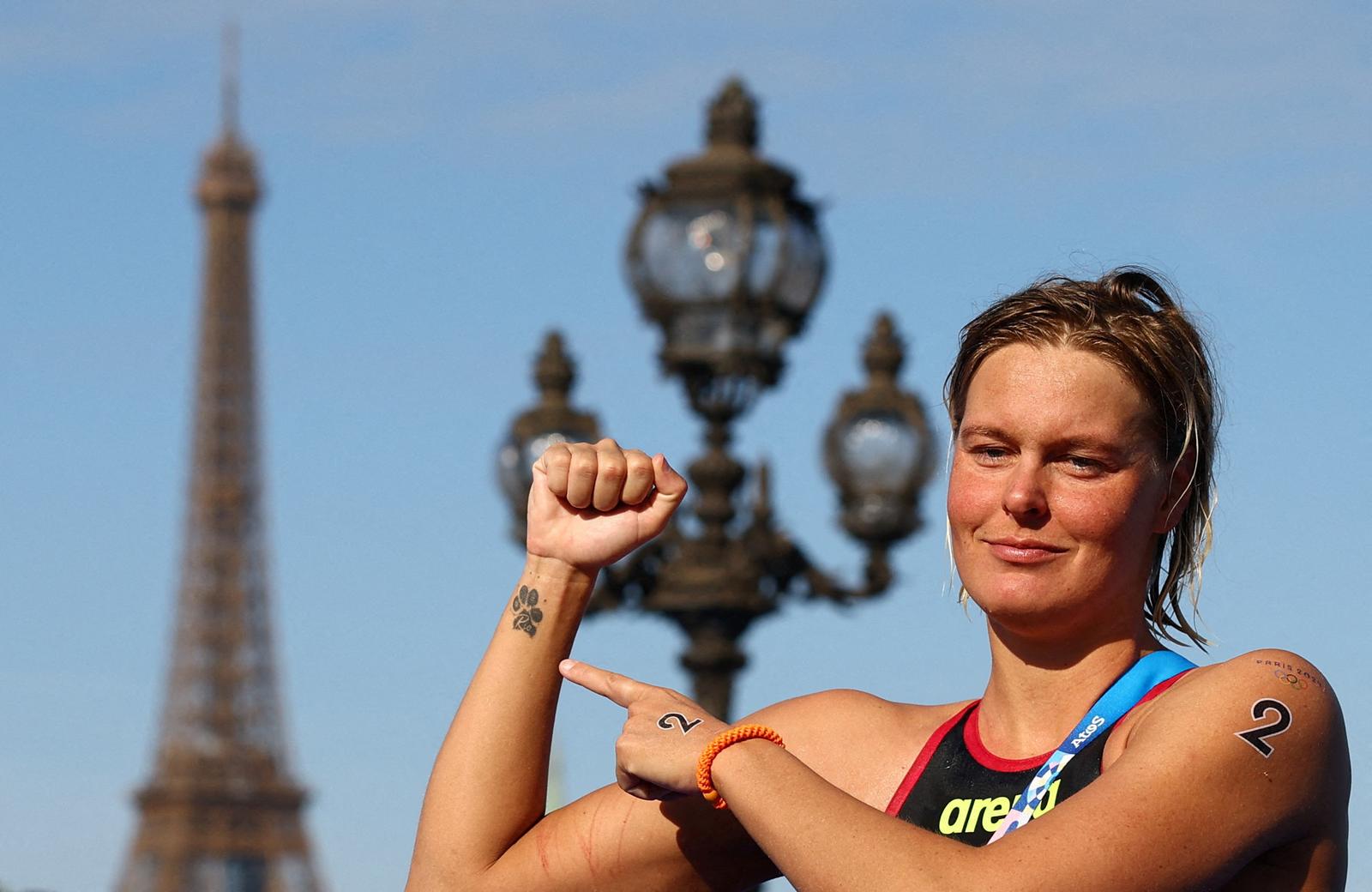 Paris 2024 Olympics - Marathon Swimming - Women's 10km - Paris, France - August 08, 2024. Gold medallist Sharon van Rouwendaal of Netherlands celebrates after the race as the Eiffel Tower is seen. REUTERS/Piroschka Van De Wouw     TPX IMAGES OF THE DAY Photo: Piroschka van de Wouw/REUTERS