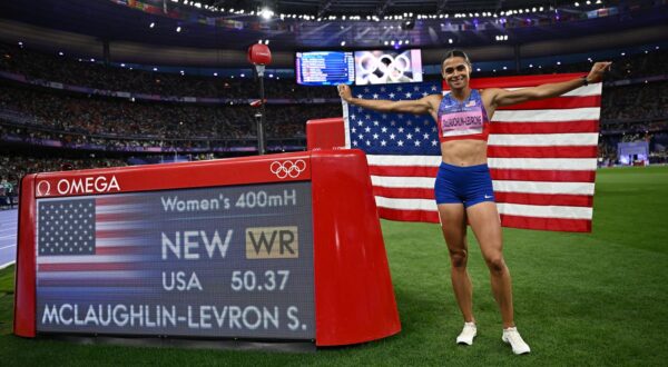 Paris 2024 Olympics - Athletics - Women's 400m Hurdles Final - Stade de France, Saint-Denis, France - August 08, 2024. Sydney McLaughlin-Levrone of United States celebrates with her national flag after winning gold and a new world record. REUTERS/Dylan Martinez Photo: Dylan Martinez/REUTERS