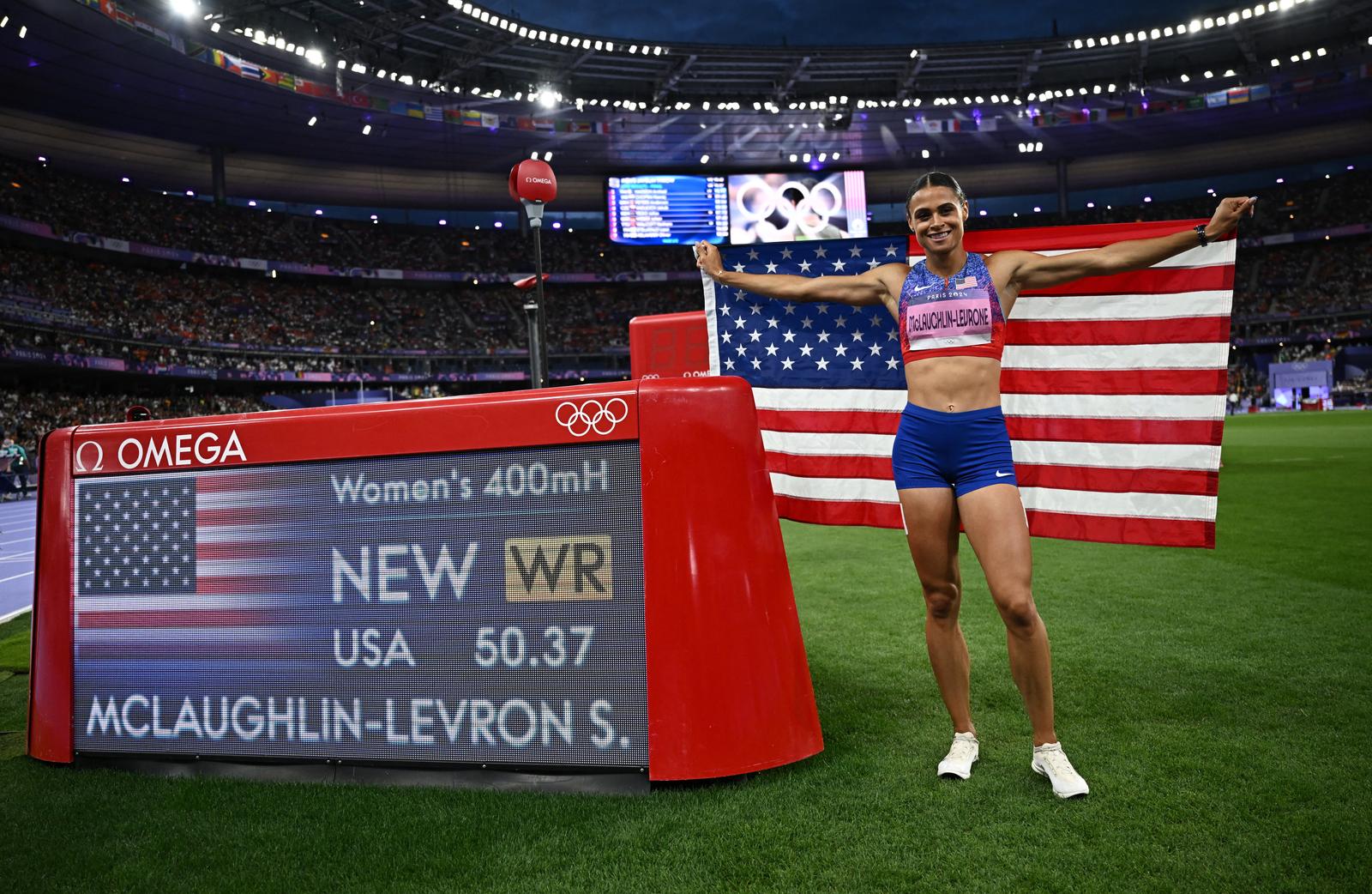 Paris 2024 Olympics - Athletics - Women's 400m Hurdles Final - Stade de France, Saint-Denis, France - August 08, 2024. Sydney McLaughlin-Levrone of United States celebrates with her national flag after winning gold and a new world record. REUTERS/Dylan Martinez Photo: Dylan Martinez/REUTERS