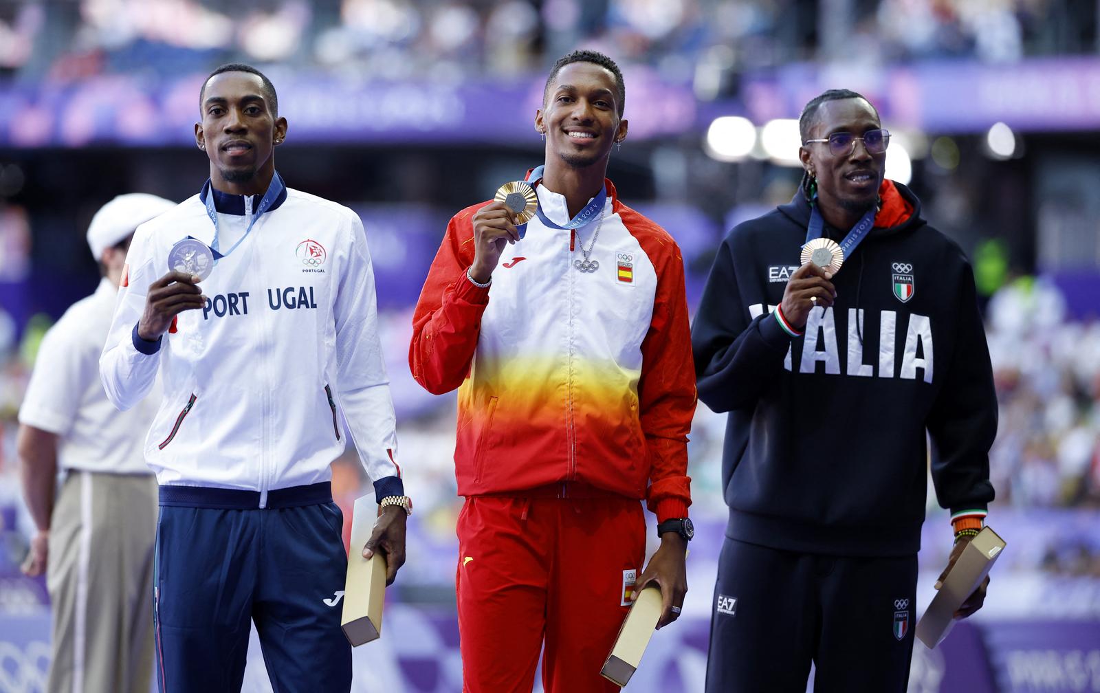 Paris 2024 Olympics - Athletics - Men's Triple Jump Victory Ceremony - Stade de France, Saint-Denis, France - August 10, 2024. Gold medallist Jordan Alejandro Diaz Fortun of Spain celebrates on the podium with silver medallist Pedro Pichardo of Portugal and bronze medallist Andy Diaz Hernandez of Italy. REUTERS/Sarah Meyssonnier Photo: Sarah Meyssonnier/REUTERS