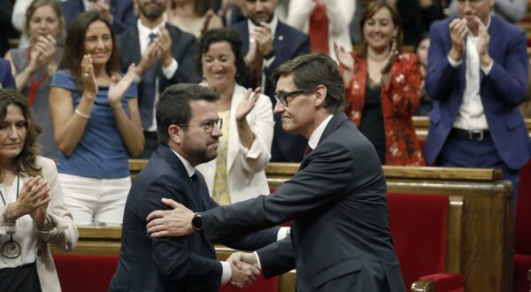 epa11537627 Socialist leader Salvador Illa (R) greets acting Catalonia's regional president Pere Aragones (L), after being invested as the Catalonia's new president at the Parliament, in Barcelona, Spain, 08 August 2024. The plenary session of the Parliament invested the Socialist leader Salvador Illa as the new president of the Generalitat, the government of Catalonia, with 68 votes in favor and 66 against. The Mossos d'Esquadra was deployed early morning on 08 August to secure access to the Parliament for the investiture of Salvador Illa.  EPA/ANDREU DALMAU