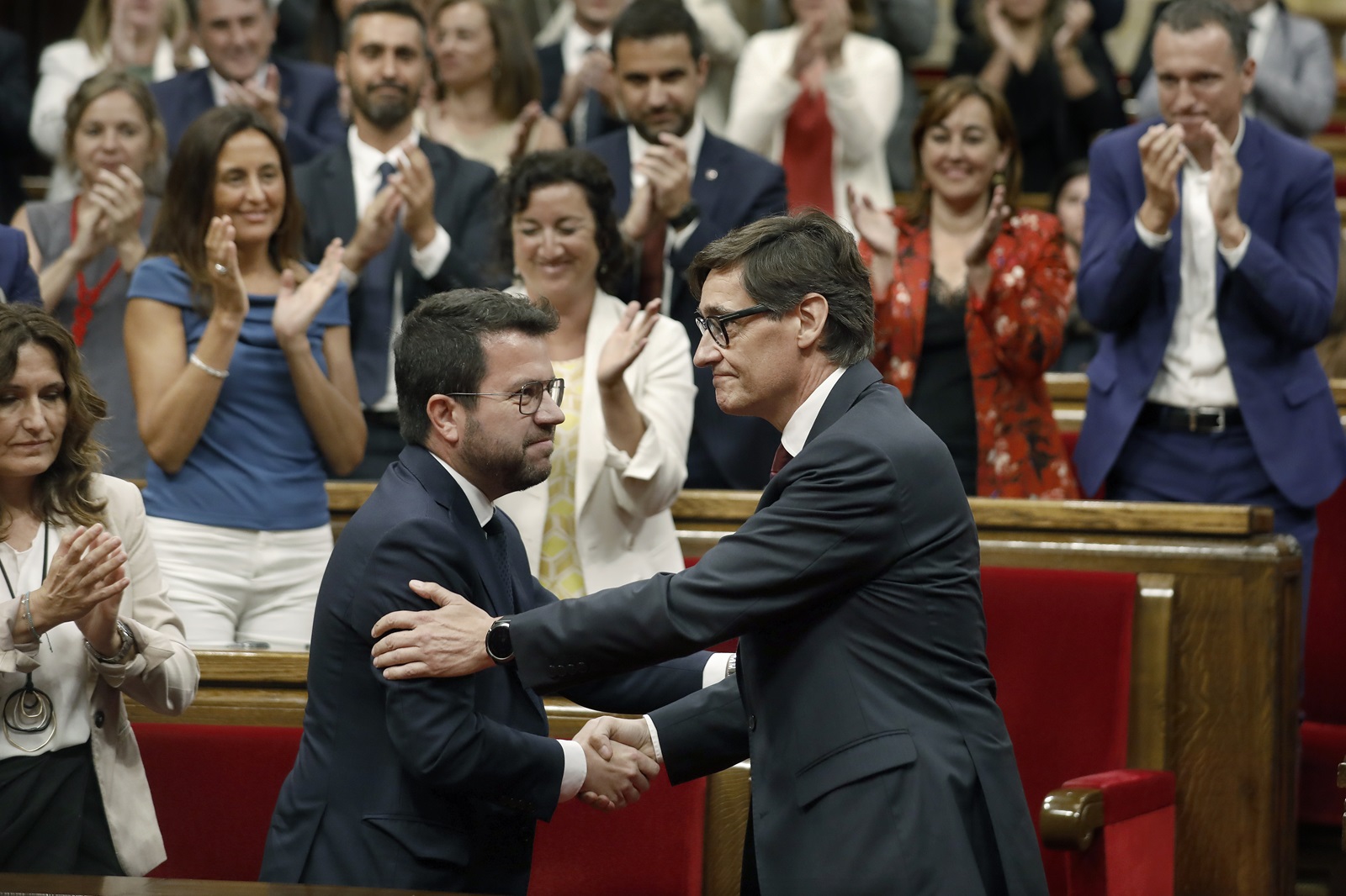 epa11537627 Socialist leader Salvador Illa (R) greets acting Catalonia's regional president Pere Aragones (L), after being invested as the Catalonia's new president at the Parliament, in Barcelona, Spain, 08 August 2024. The plenary session of the Parliament invested the Socialist leader Salvador Illa as the new president of the Generalitat, the government of Catalonia, with 68 votes in favor and 66 against. The Mossos d'Esquadra was deployed early morning on 08 August to secure access to the Parliament for the investiture of Salvador Illa.  EPA/ANDREU DALMAU