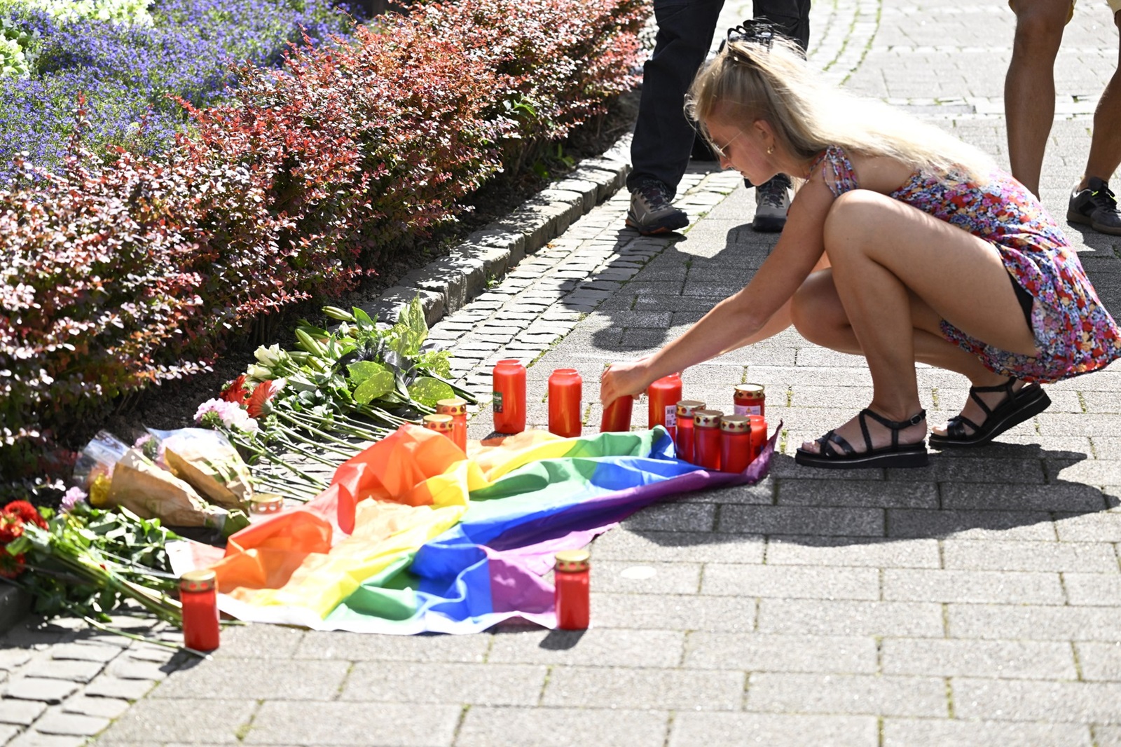 A young woman lights a candle at a makeshift memorial of flowers and a rainbow flag for the victims on August 24, 2024 close to the scene where at least three people were killed and several injured when a man attacked them with a knife on late August 23, 2024 in Solingen, western Germany, during a festival to mark the city's 650th anniversary. German police stepped up a major hunt for a man who stabbed three people to death and wounded eight others at the street festival, authorities said. Police closed off the centre of Solingen after the attack at the city's "Festival of Diversity". A police statement said five of the wounded were in "serious" condition.,Image: 901184603, License: Rights-managed, Restrictions: , Model Release: no, Credit line: Roberto Pfeil / AFP / Profimedia