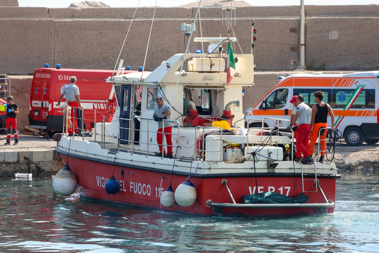 Italian firefighters transport a body bag with a victim after a sailboat sank off the coast of Porticello, nosthwestern of Sicily Island, on August 19, 2024. One person was killed and rescuers were searching for six others missing after a luxury superyacht called "The Bayesian" with 22 people aboard majority of those were British, sank during a sudden storm off the coast of Italy's Sicily, officials said, on August 19, 2024.,Image: 899844702, License: Rights-managed, Restrictions: Italy OUT / -- IMAGE RESTRICTED TO EDITORIAL USE - STRICTLY NO COMMERCIAL USE --, Model Release: no, Credit line: Igor Petyx / AFP / Profimedia