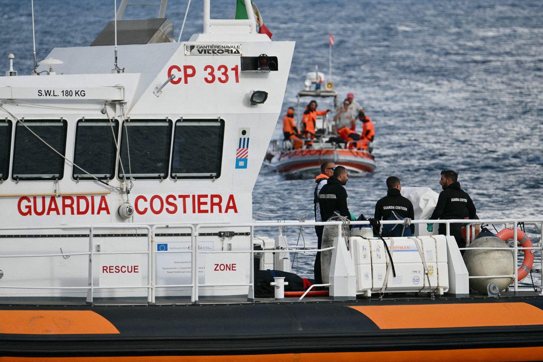 Italian Coast Guards carry a body on a rescue boat in Porticello harbor near Palermo, with a third body at the back of the boat on August 21, 2024, two days after the British-flagged luxury yacht Bayesian sank. Divers searching for six missing people following the sinking of a superyacht off Sicily in a storm have found four bodies, a source close to the search told AFP.  The Bayesian, which had 22 people aboard including 10 crew, was anchored some 700 metres from port before dawn when it was struck by a waterspout. Among the six missing were UK tech entrepreneur Mike Lynch and his 18-year-old daughter Hannah, and Jonathan Bloomer, the chair of Morgan Stanley International, and his wife Judy.,Image: 900429092, License: Rights-managed, Restrictions: , Model Release: no, Credit line: Alberto PIZZOLI / AFP / Profimedia