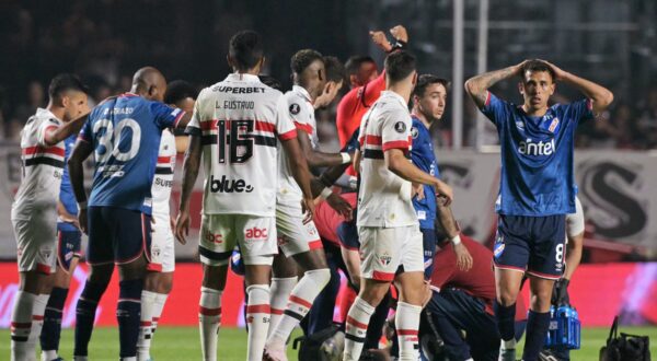 Nacional's defender Juan Manuel Izquierdo (covered) receives medical attention after collapsing onto the ground during the Copa Libertadores round of 16 second leg football match between Brazil's Sao Paulo and Uruguay's Nacional at the MorumBIS stadium in Sao Paulo, Brazil, on August 22, 2024.,Image: 900822339, License: Rights-managed, Restrictions: , Model Release: no, Credit line: NELSON ALMEIDA / AFP / Profimedia