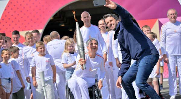 French President of the Paris 2024 Olympics and Paralympics Organising Committee (COJO) Tony Estanguet (R) takes a selfie with Former French wheelchair fencer Emmanuelle Assmann holding the torch of the Paris 2024 Paralympic Games after arrival of the Paralympics flame at the entrance of the Channel Tunnel in Coquelles, northern France on August 25, 2024. The Paris 2024 Paralympics flame was lit in Stoke Mandeville of England and it will pass through the Channel Tunnel with 24 British torchbearers taking it halfway to hand over to 24 French torchbearers, who will take the torches to Calais, then 12 torches will travel across France from August 25, 2024 to August 28.,Image: 901427093, License: Rights-managed, Restrictions: , Model Release: no, Credit line: LOU BENOIST / AFP / Profimedia