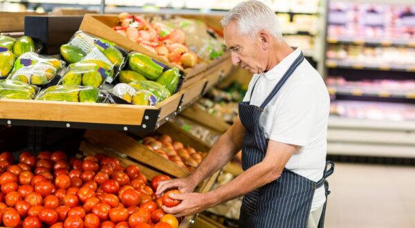 Serious senior worker taking tomato in supermarket,Image: 279960134, License: Royalty-free, Restrictions: , Model Release: yes, Credit line: - / Wavebreak / Profimedia