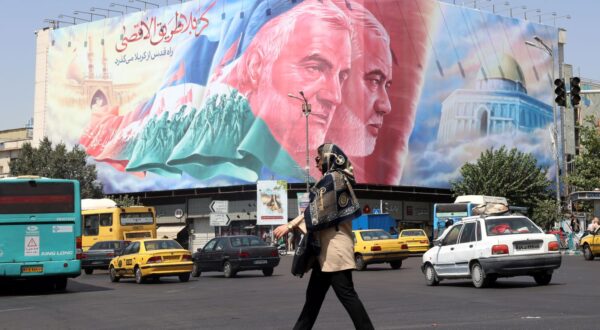 epa11566614 People walk past to a huge billboard of late Iranian Hamas leader Ismail Haniyeh and late Iranian Quds forces commander Ghasem Soleimnai at Enghelab Square in Tehran, Iran, 27 August 2024. Tension remains high between Iran and Israel since Ismail Haniyeh was killed in Tehran on 31 July 2024. According to the official news agency Irna, newly appointed Iranian Foreign Minister Abbas Araghchi said on 26 August that Iran will respond against Israel in retaliation for the killing of Haniyeh.  EPA/ABEDIN TAHERKENAREH