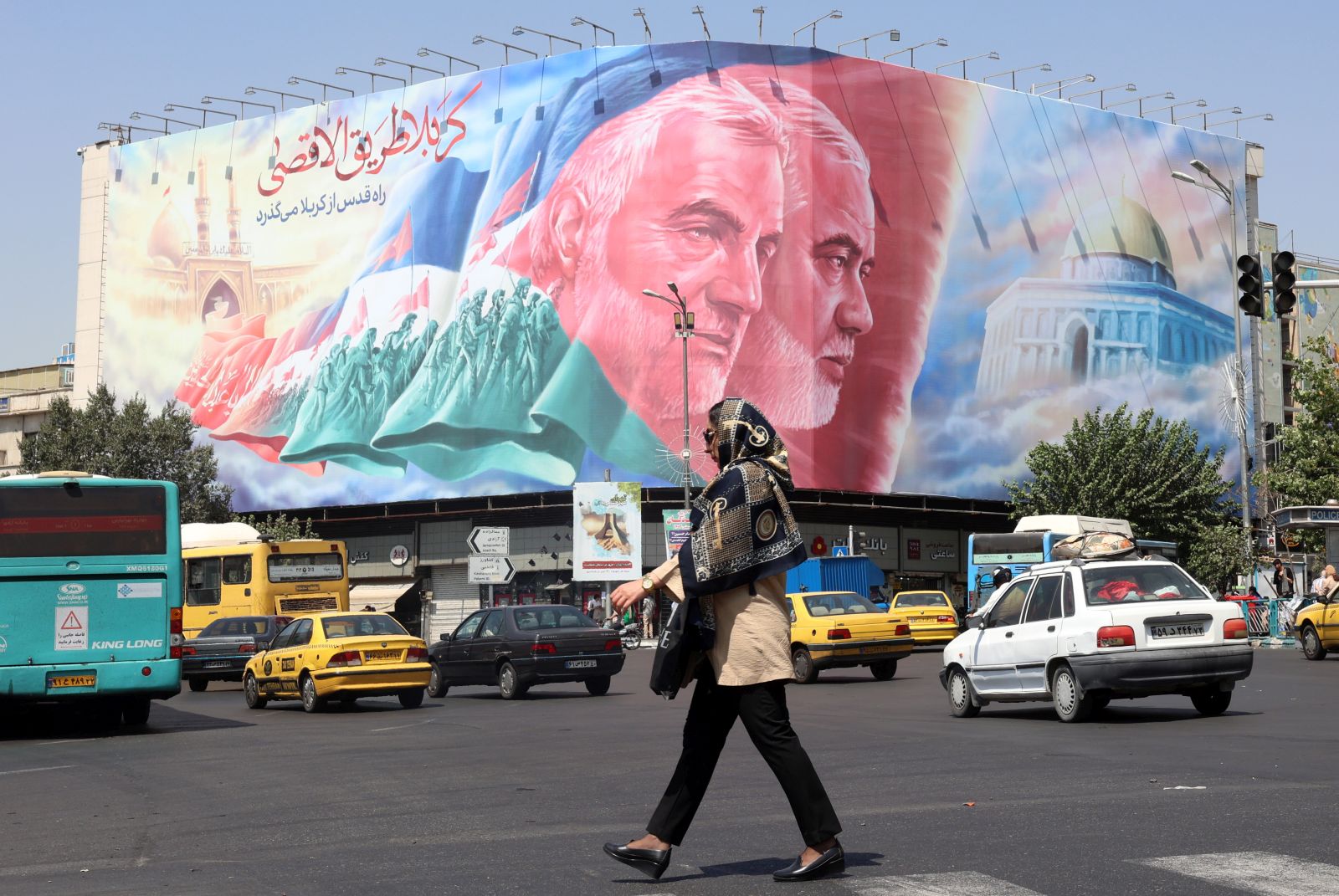 epa11566614 People walk past to a huge billboard of late Iranian Hamas leader Ismail Haniyeh and late Iranian Quds forces commander Ghasem Soleimnai at Enghelab Square in Tehran, Iran, 27 August 2024. Tension remains high between Iran and Israel since Ismail Haniyeh was killed in Tehran on 31 July 2024. According to the official news agency Irna, newly appointed Iranian Foreign Minister Abbas Araghchi said on 26 August that Iran will respond against Israel in retaliation for the killing of Haniyeh.  EPA/ABEDIN TAHERKENAREH