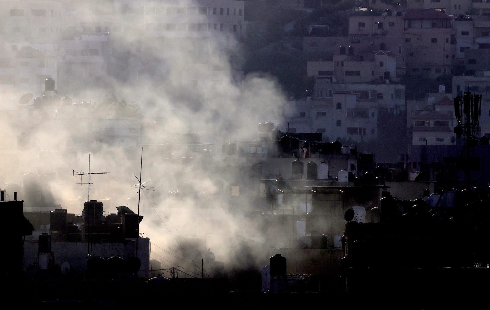 epa11575946 Smokes rises over Jenin camp during heavy clashes on the fourth day of an Israeli military operation in the West Bank city of Jenin, 31 August 2024. According to the Palestinian Health Ministry, at least 20 Palestinians have been killed since Israeli military operations started on 28 August 2024 in the West Bank cities of Tulkarem, Jenin and Tubas. The Israeli army said that it's conducting a large-scale 'counter-terrorism operation' in several areas.  EPA/ALAA BADARNEH