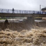 epa11603534 A local man walks on a bridge over the overflowing Bela river in Mikulovice, Czech Republic, 14 September 2024. The Czech Hydrometeorological Institute (CHMU) has issued a extreme precipitation warning of unusually intense rainfall which can significantly raise water levels and that will affect the Czech Republic from 12 September until the end of the week.  EPA/MARTIN DIVISEK