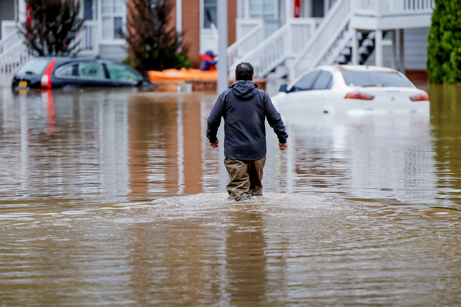 epa11628778 A man wades through the flood waters at the Peachtree Park Apartments after Tropical Storm Helene raced through Atlanta, Georgia, USA, 27 September 2024. Hurricane Helene made landfall near Perry, Florida and several deaths have been reported in Georgia.  EPA/ERIK S. LESSER