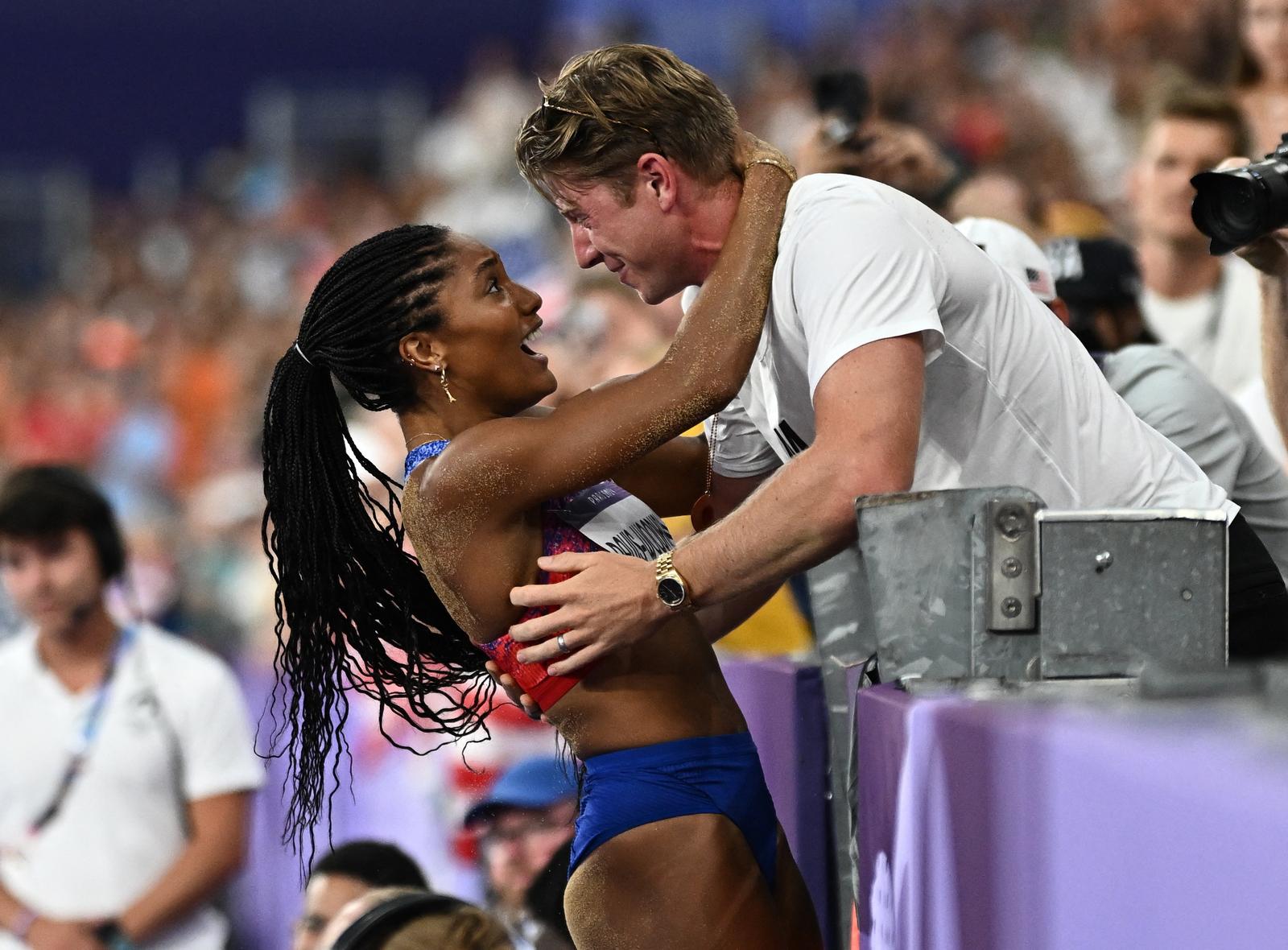 Paris 2024 Olympics - Athletics - Women's Long Jump Final - Stade de France, Saint-Denis, France - August 08, 2024. Tara Davis-Woodhall of United States celebrates with her husband Hunter Woodhall after winning gold. REUTERS/Dylan Martinez Photo: Dylan Martinez/REUTERS