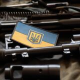 The patch of the flag of Ukraine lies on a disassembled machine gun on a green camouflage fabric, war in Ukraine, military weapons,Image: 702542404, License: Royalty-free, Restrictions: , Model Release: no, Credit line: / Alamy / Alamy / Profimedia