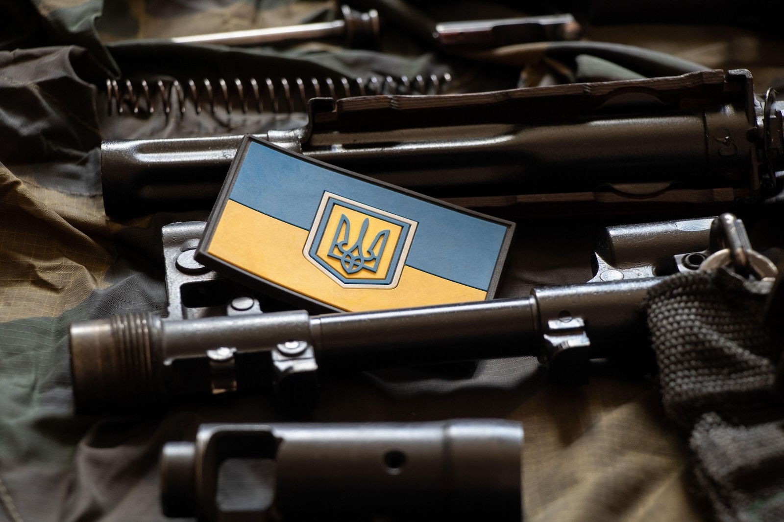 The patch of the flag of Ukraine lies on a disassembled machine gun on a green camouflage fabric, war in Ukraine, military weapons,Image: 702542404, License: Royalty-free, Restrictions: , Model Release: no, Credit line: / Alamy / Alamy / Profimedia