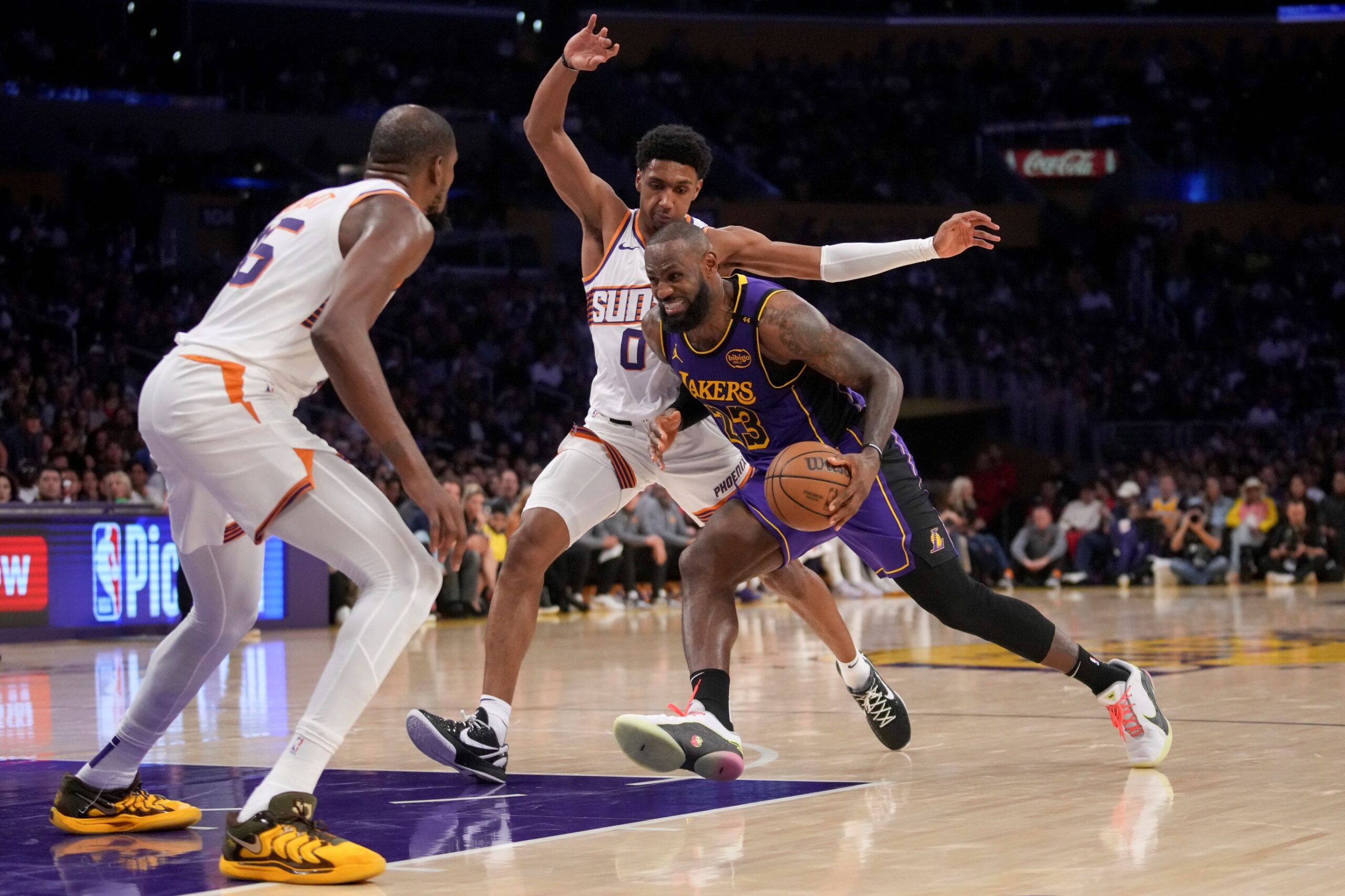 Los Angeles Lakers forward LeBron James (23) drives against Phoenix Suns forwards Kevin Durant, left, and Ryan Dunn (0) during the second half of an NBA basketball game in Los Angeles, Friday, Oct. 25, 2024. (AP Photo/Eric Thayer) Suns Lakers Basketball