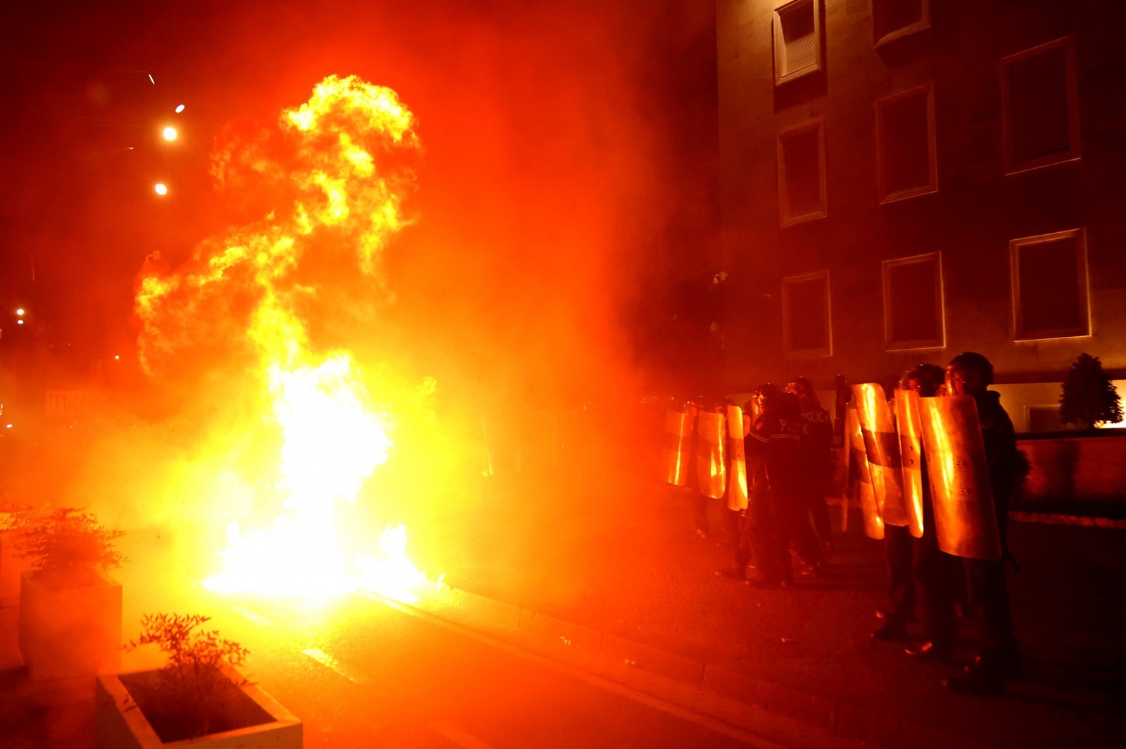 Riot police officers stand in a street as molotov cocktails explode outside the government building, thrown by opposition protesters who demand the resignation of the government and the release of opposition MP Ervin Salianji, in Tirana, on October 7, 2024. Clashes broke out late Monday in Tirana between police and opposition protesters seeking that longtime leftist Prime Minister Edi Rama resigns, leaving 10 officers injured police said. A few thousand people gathered in the Albanian capital at demonstrations organised by the country's right-wing opposition, according to an AFP reporter.,Image: 917830156, License: Rights-managed, Restrictions: , Model Release: no, Credit line: Adnan Beci / AFP / Profimedia