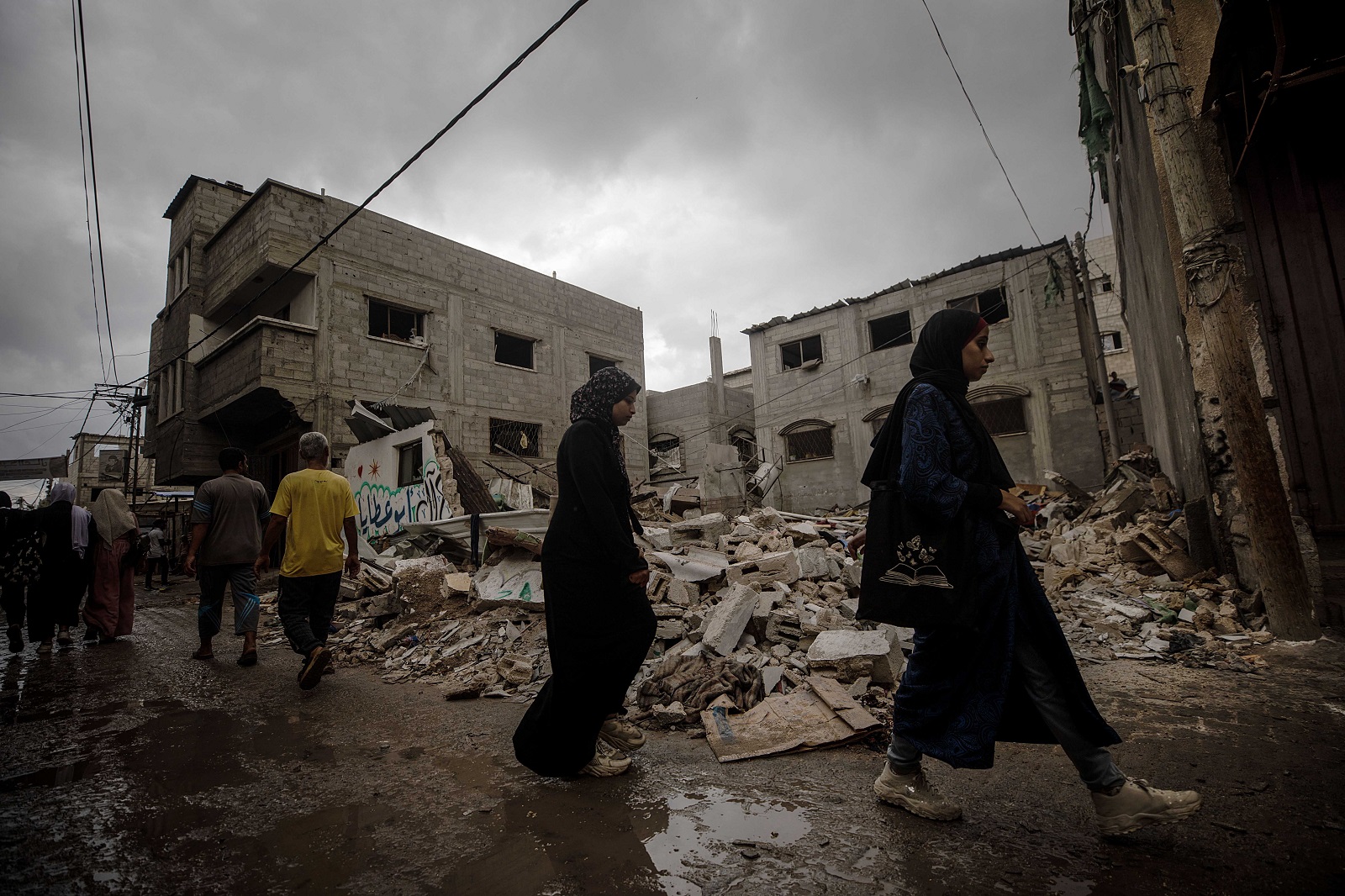 epa11635336 Palestinians walk past a destroyed house following an Israeli air strike in Al Nusairat refugee camp, central Gaza Strip, 01 October 2024. More than 41,000 Palestinians and over 1,400 Israelis have been killed, according to the Palestinian Health Ministry and the Israel Defense Forces (IDF), since Hamas militants launched an attack against Israel from the Gaza Strip on 07 October 2023, and the Israeli operations in Gaza and the West Bank which followed it.  EPA/MOHAMMED SABER