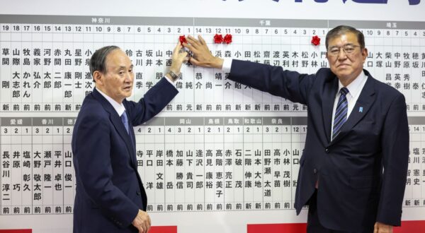 epa11687005 Japan's Prime Minister Shigeru Ishiba (R) and Yoshihide Suga, Vice President of Japan's Liberal Democratic Party (LDP), place a pin on a board showing candidate's names while speaking to the media at the LDP's headquarters, Tokyo, Japan, 27 October 2024. Exit polling suggested that the incumbent LDP would not be able to form a single-party majority government in a snap election called by Prime Minister Shigeru Ishiba.  EPA/TAKASHI AOYAMA / POOL